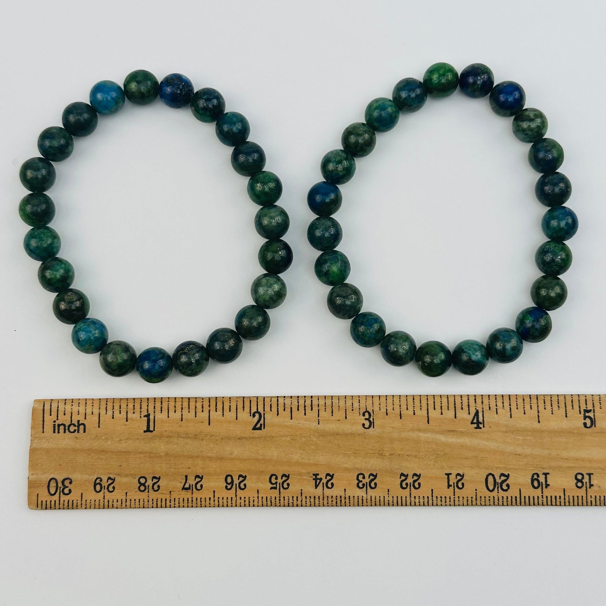 bracelets next to a ruler for size reference 