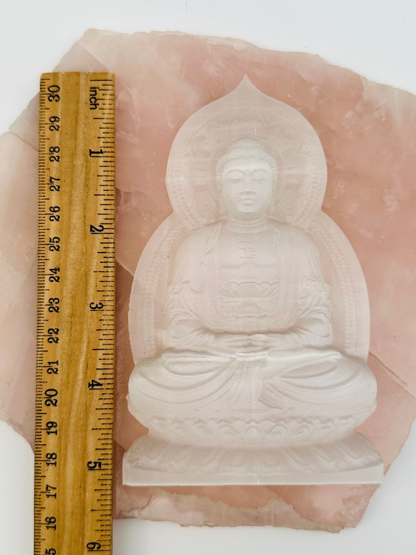 selenite carving displayed next to a ruler for size reference 