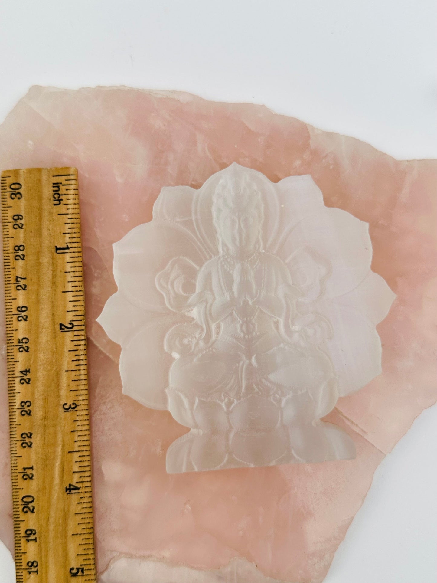 selenite carving displayed next to a ruler for size reference 