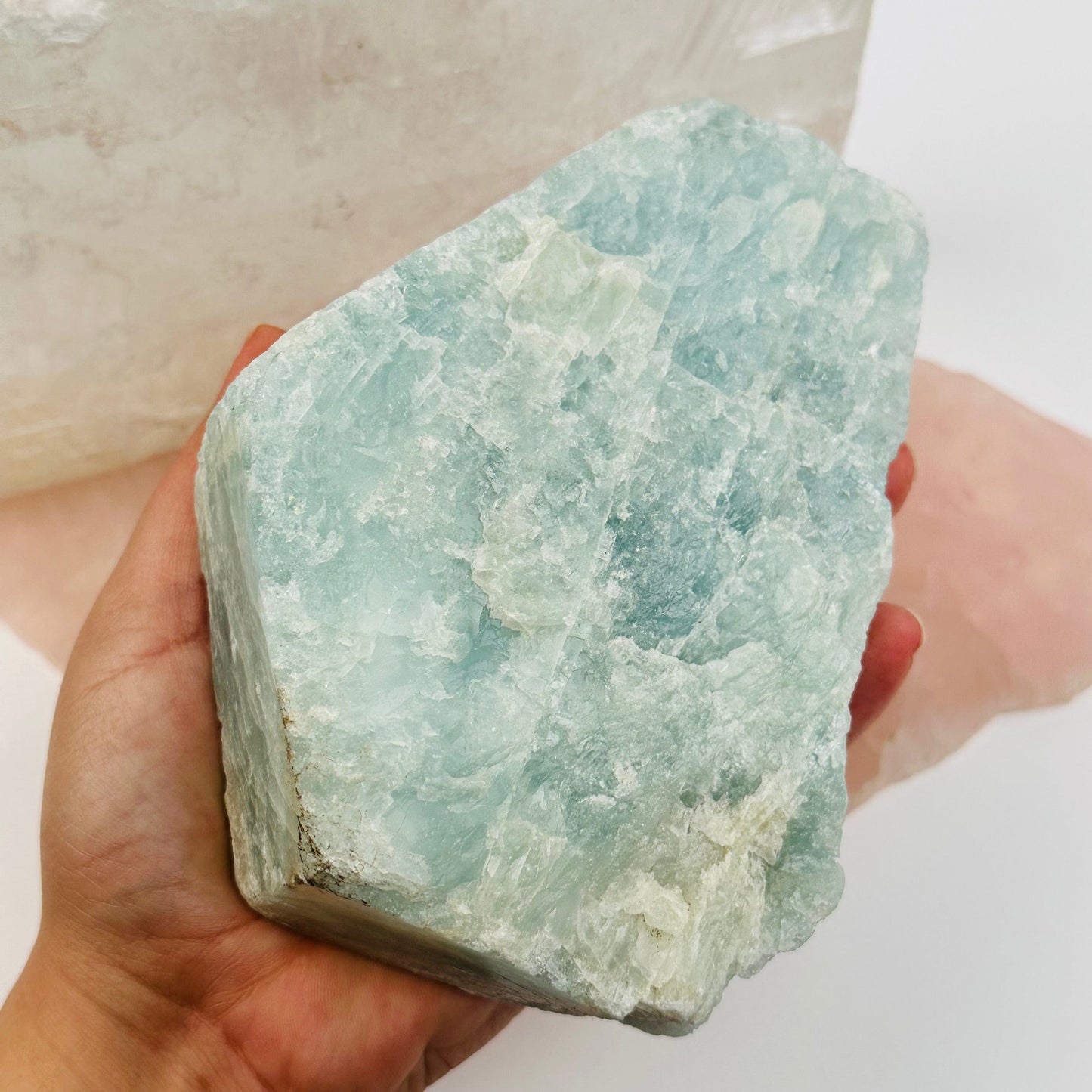 Rough Aquamarine in hand for size reference 