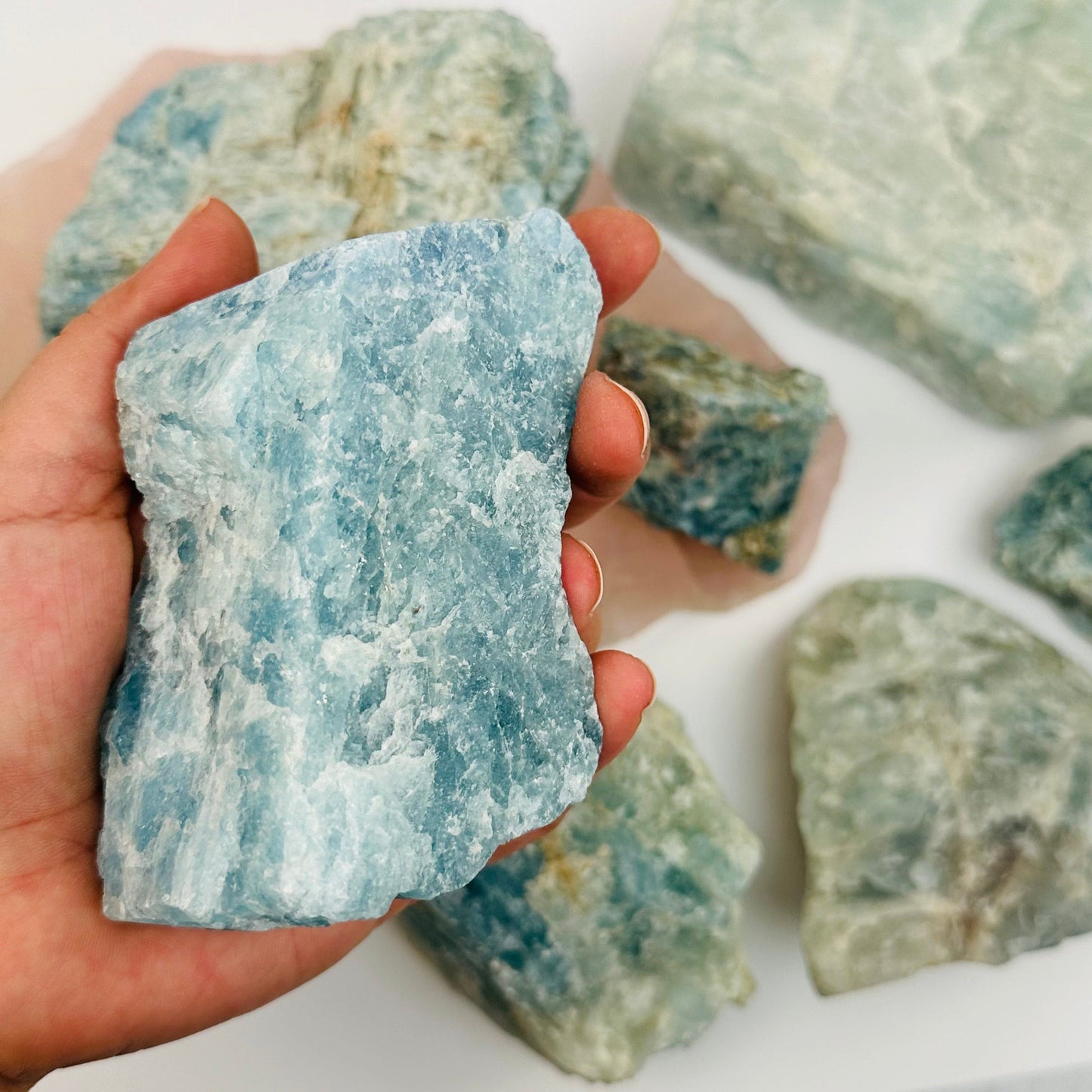 Rough Aquamarine in hand for size reference 