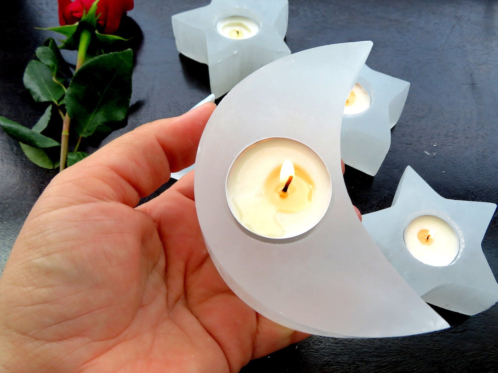 selenite crescent moon candle holder with candle (not included with purchase) in hand for size reference 