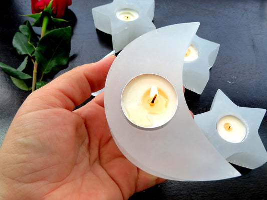 selenite crescent moon candle holder with candle (not included with purchase) in hand for size reference 