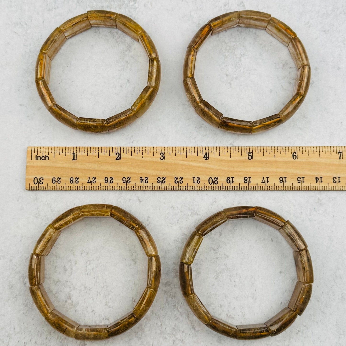 bracelets next to a ruler for size reference 