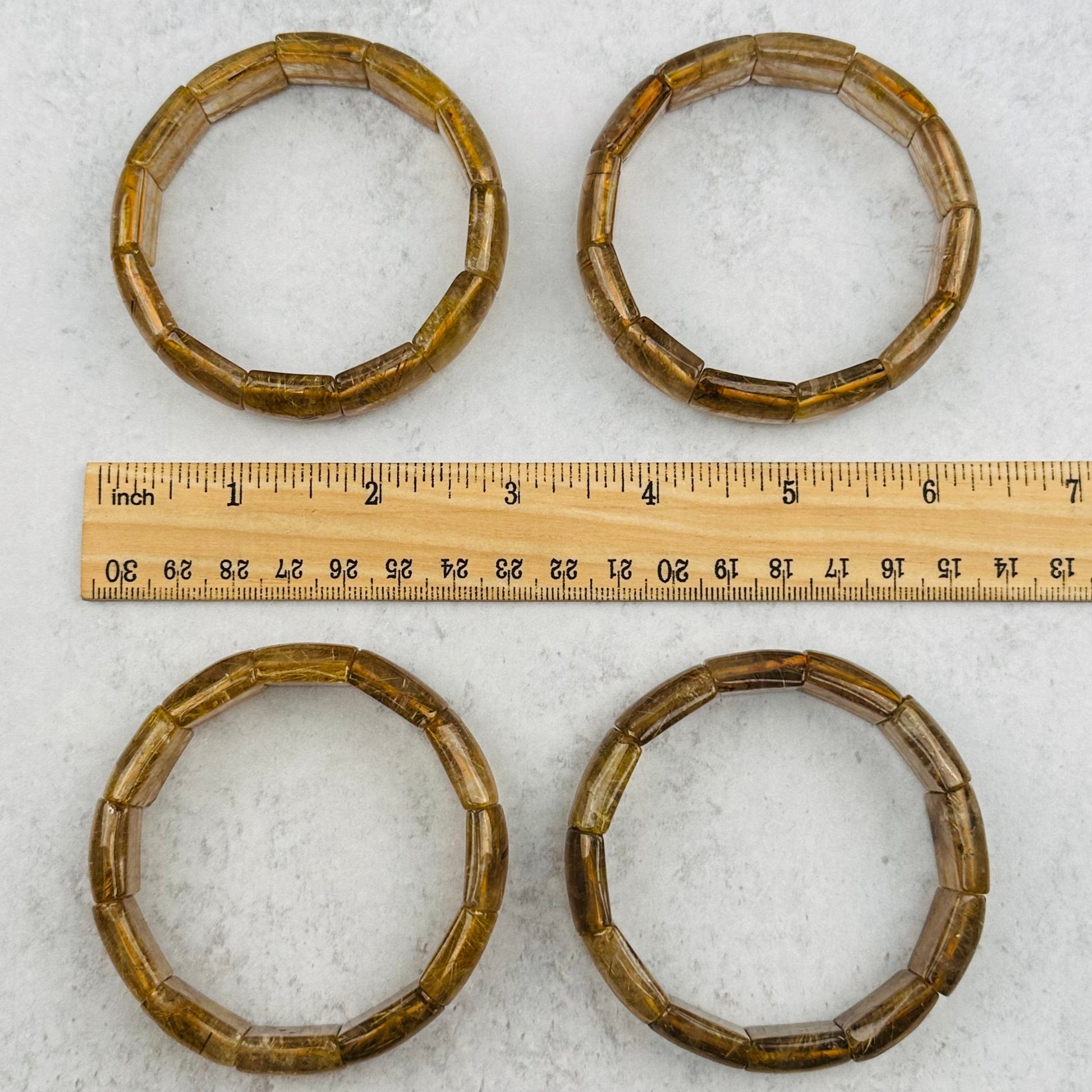 bracelets next to a ruler for size reference 