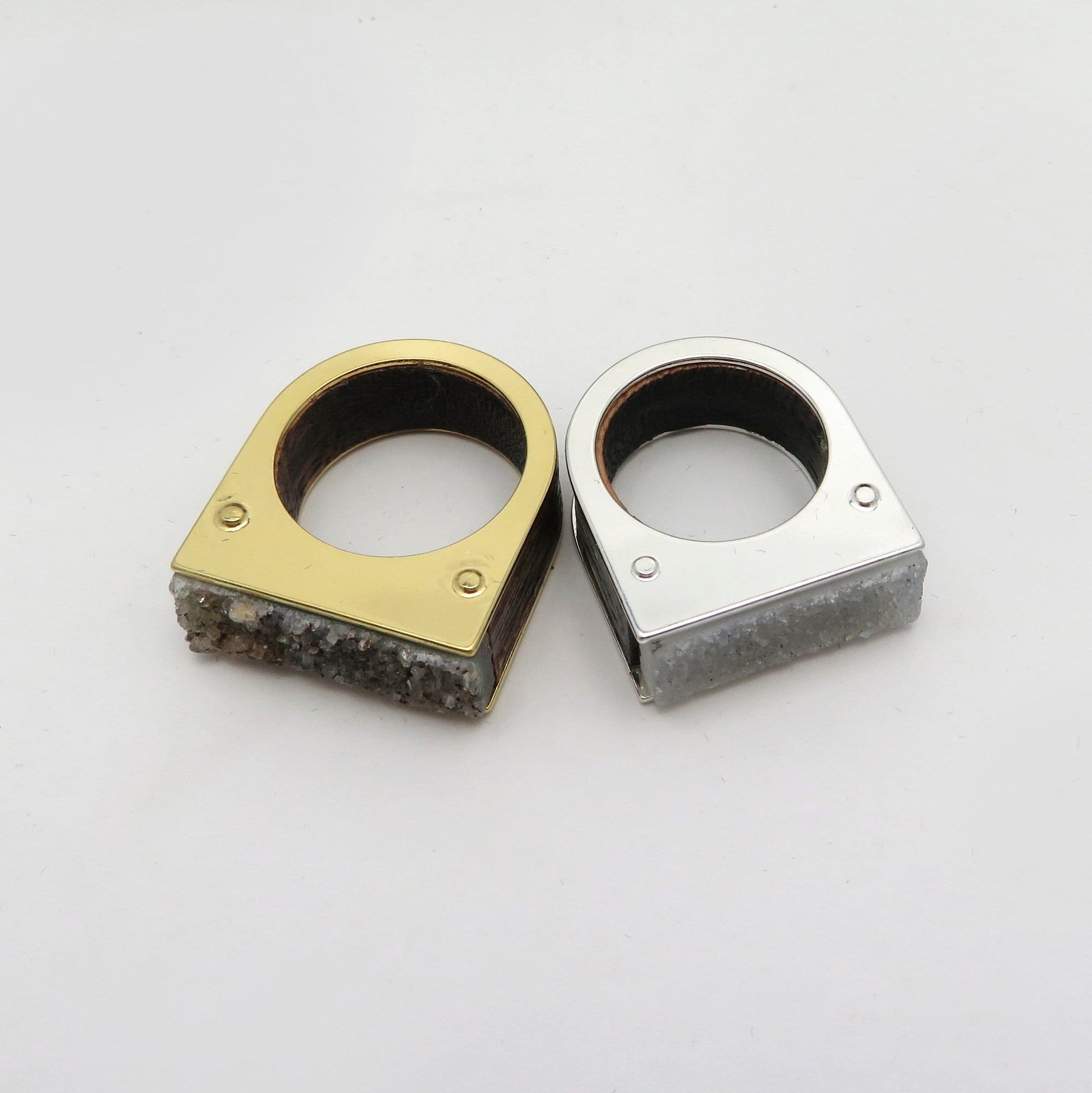 Two druzy rings on a white background.  One is gold plated and the other silver plated.  The druzy is gray in one and dark gray in another.