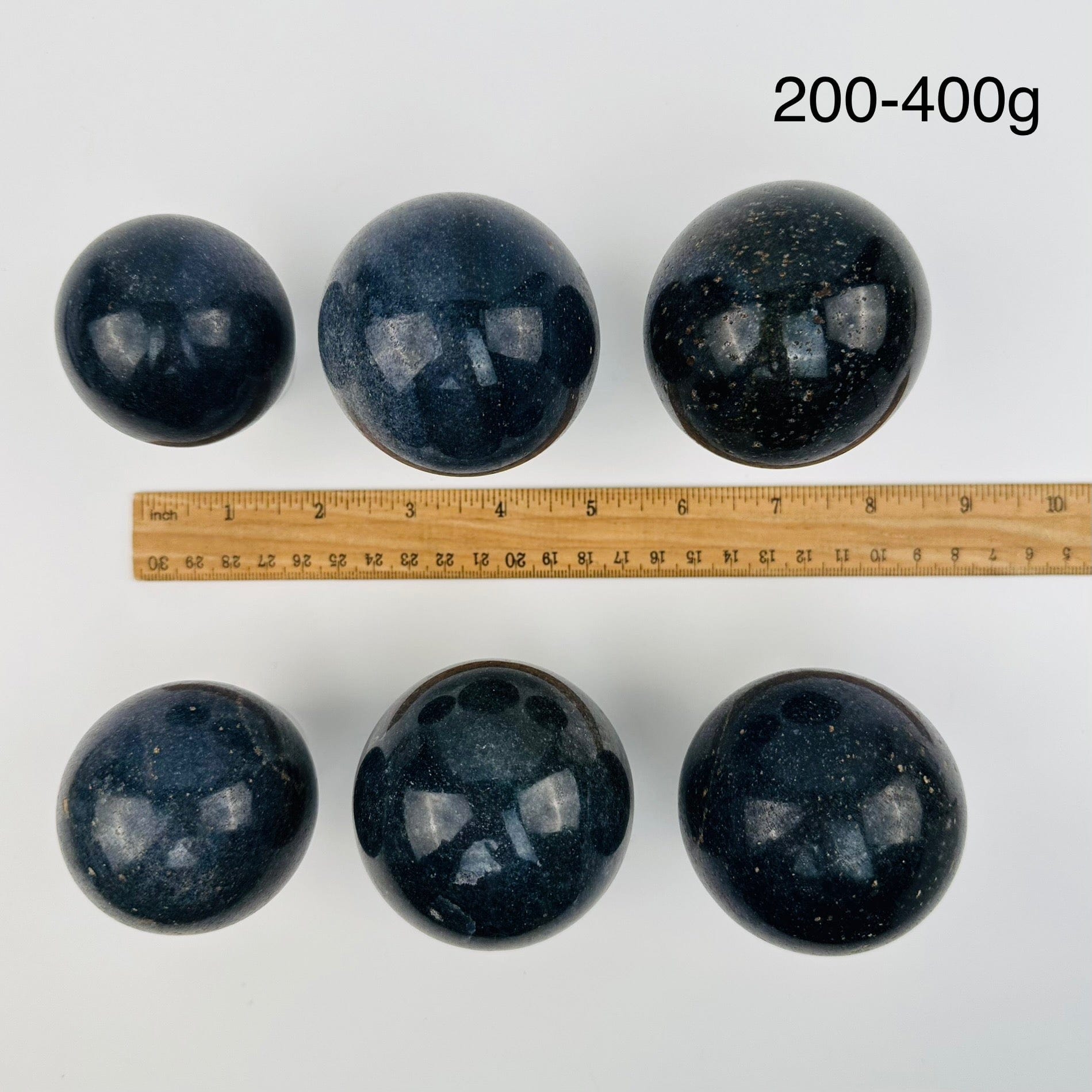 lazulite crystal spheres sold by weight. displayed next to a ruler for size reference 