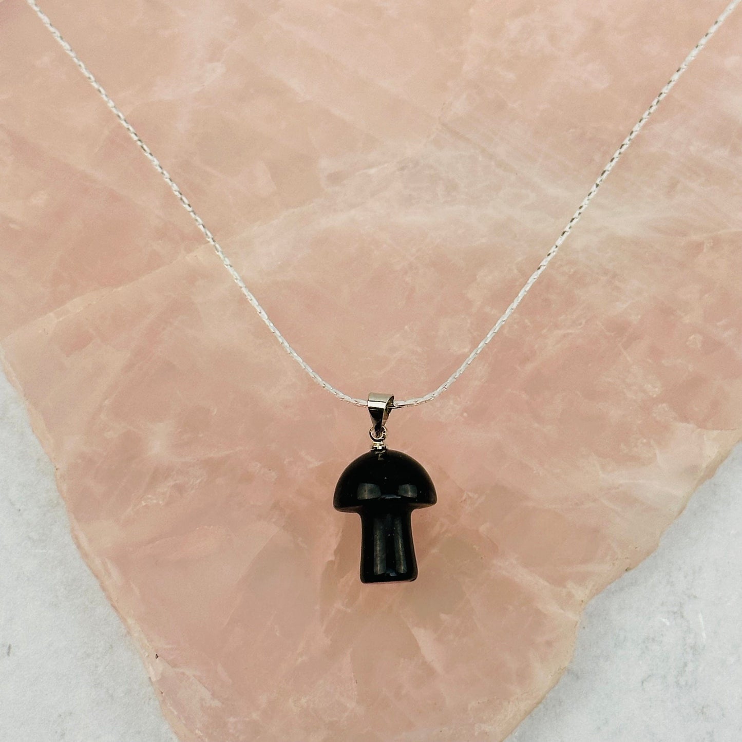 pendant displayed on a necklace wo show how it hangs 