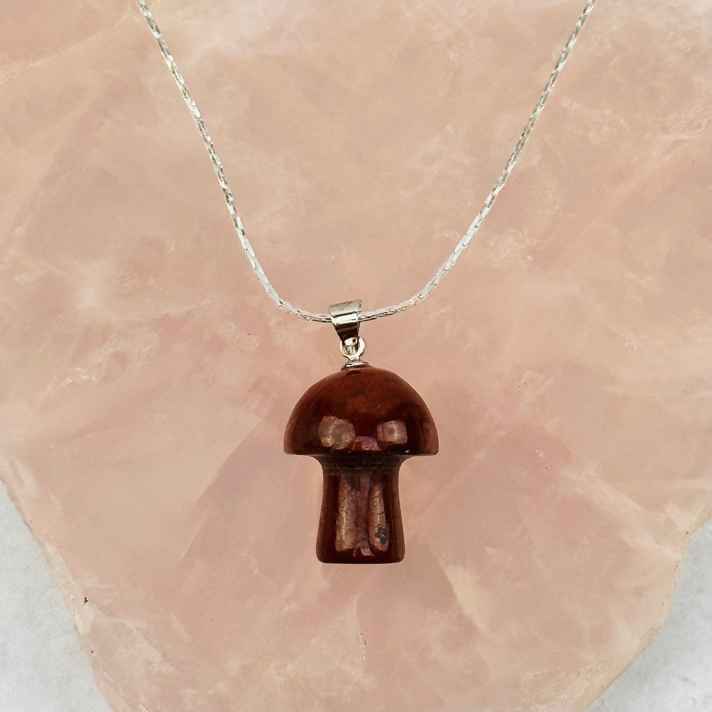 pendant displayed on a necklace wo show how it hangs