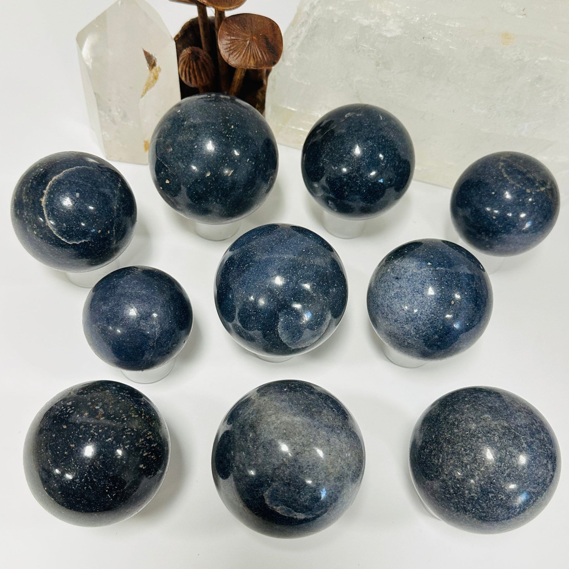 multiple lazulite crystal spheres displayed to show the differences in the sizes and color shades 