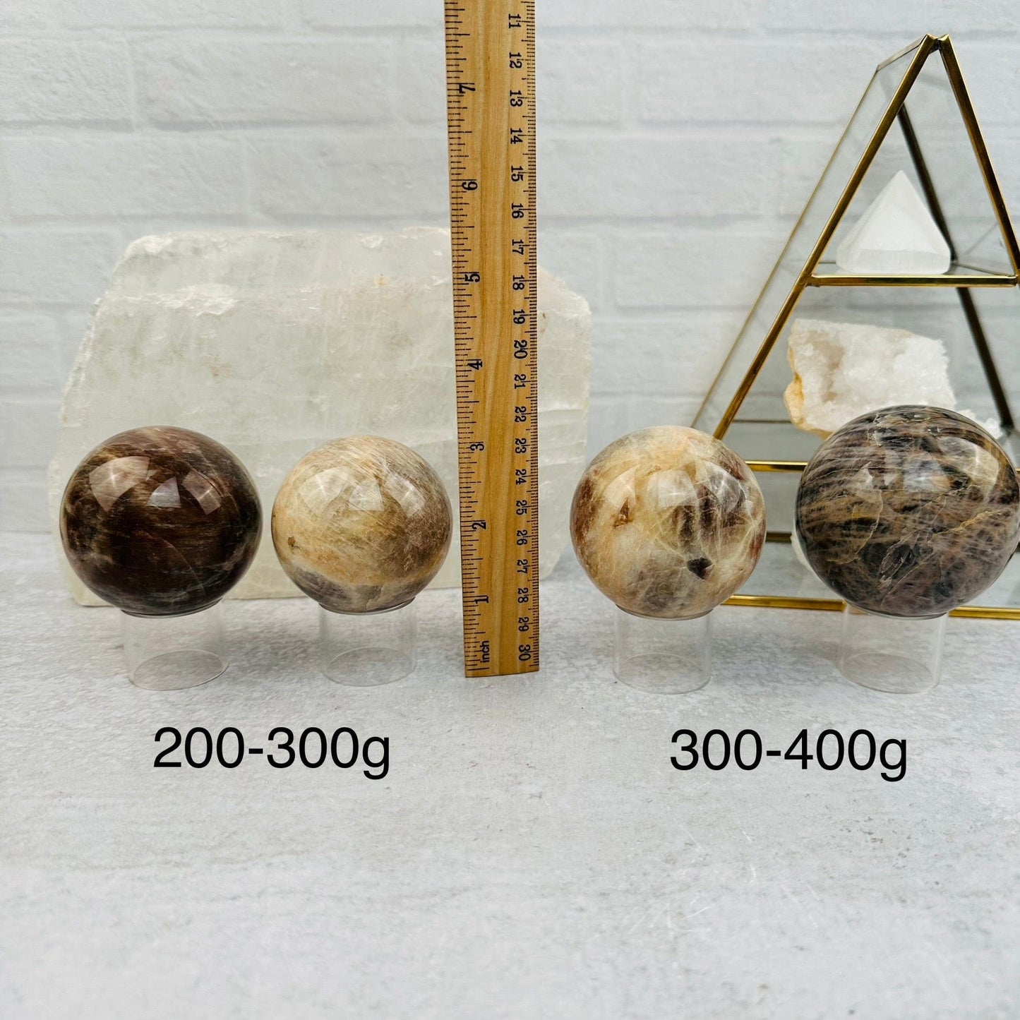 Cream Moonstone Sphere by weight next to a ruler for size reference 