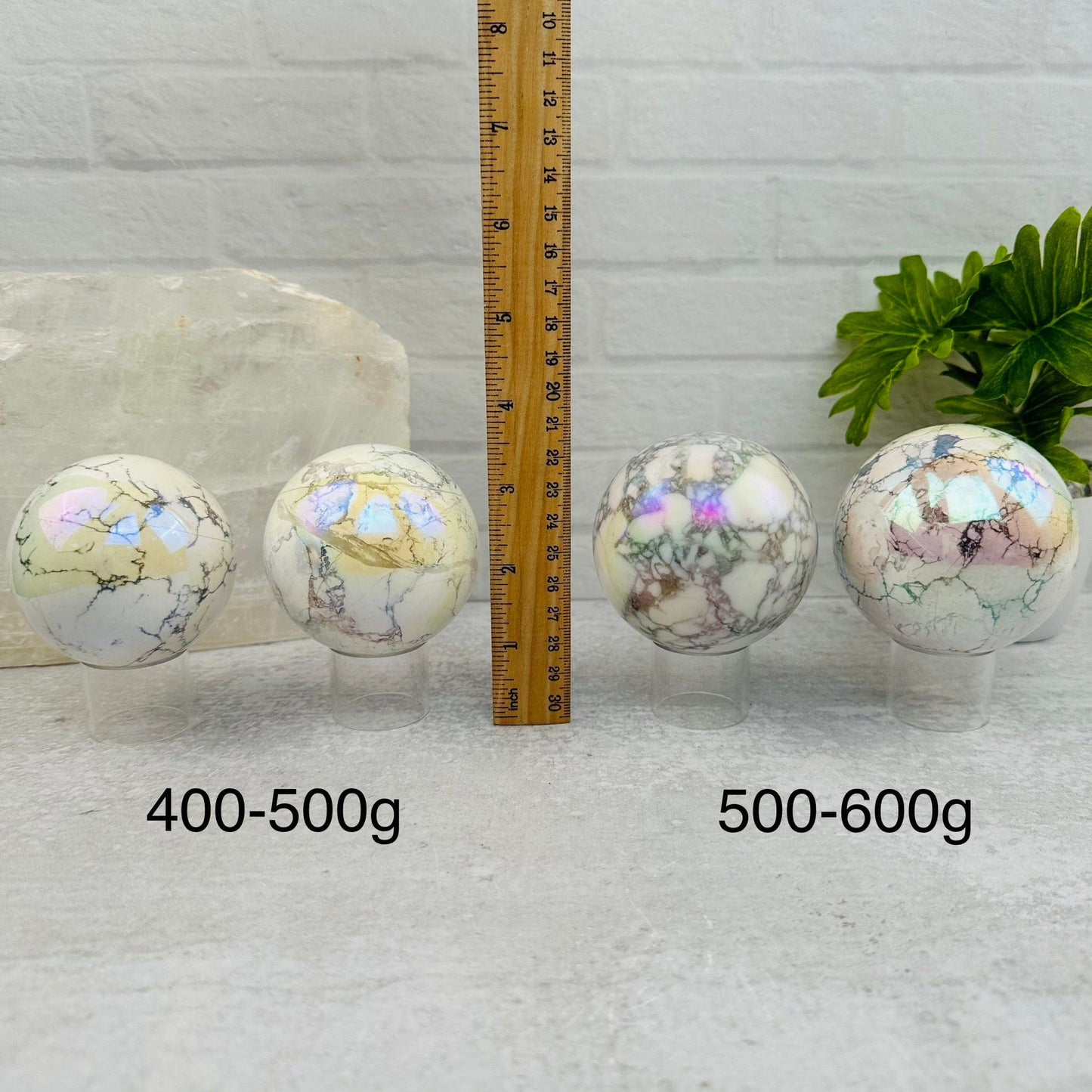 White Howlite Angel Aura Polished Spheres - By Weight - next to a ruler for size reference