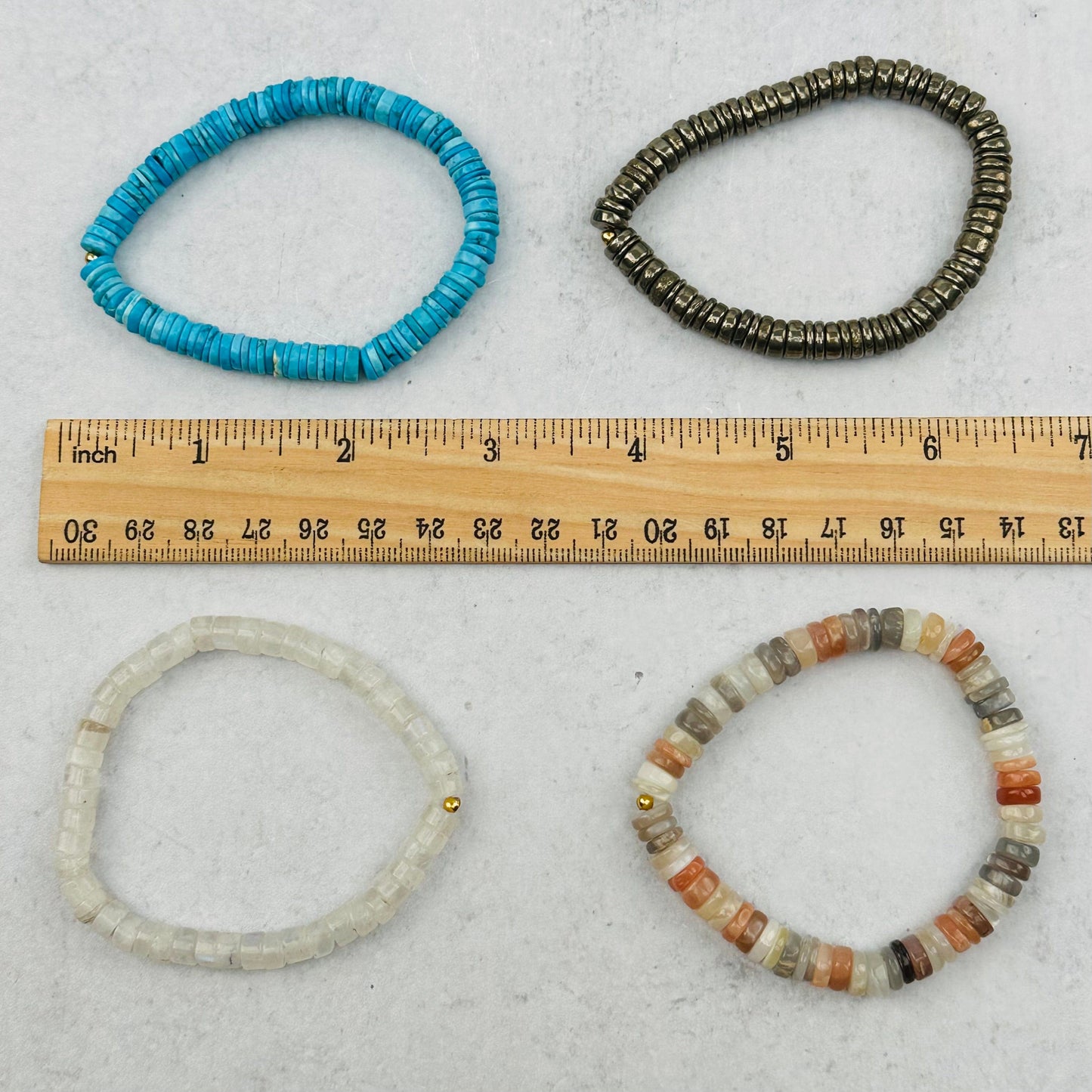 bracelets next to a ruler for size reference 