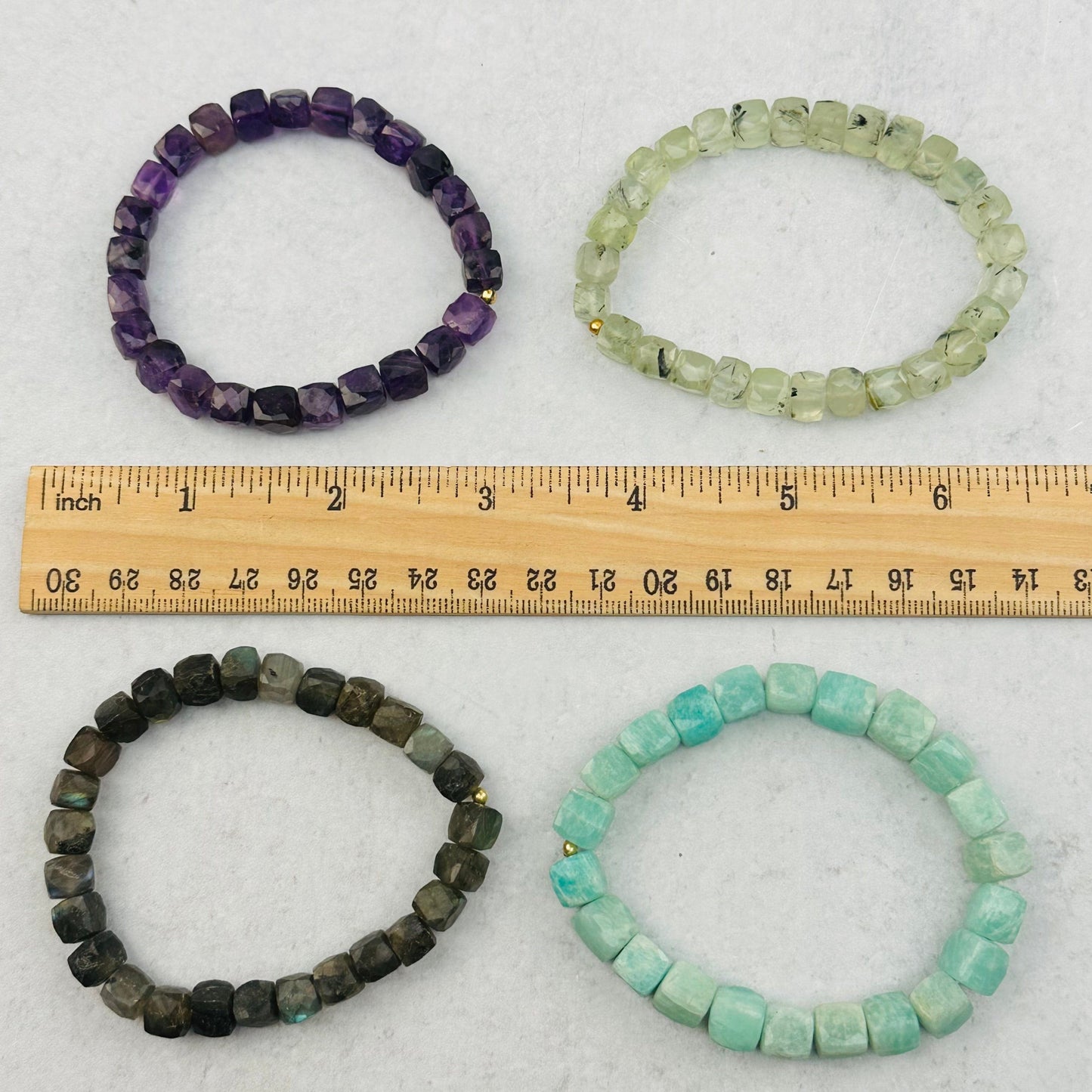 bracelets next to a ruler for size reference 