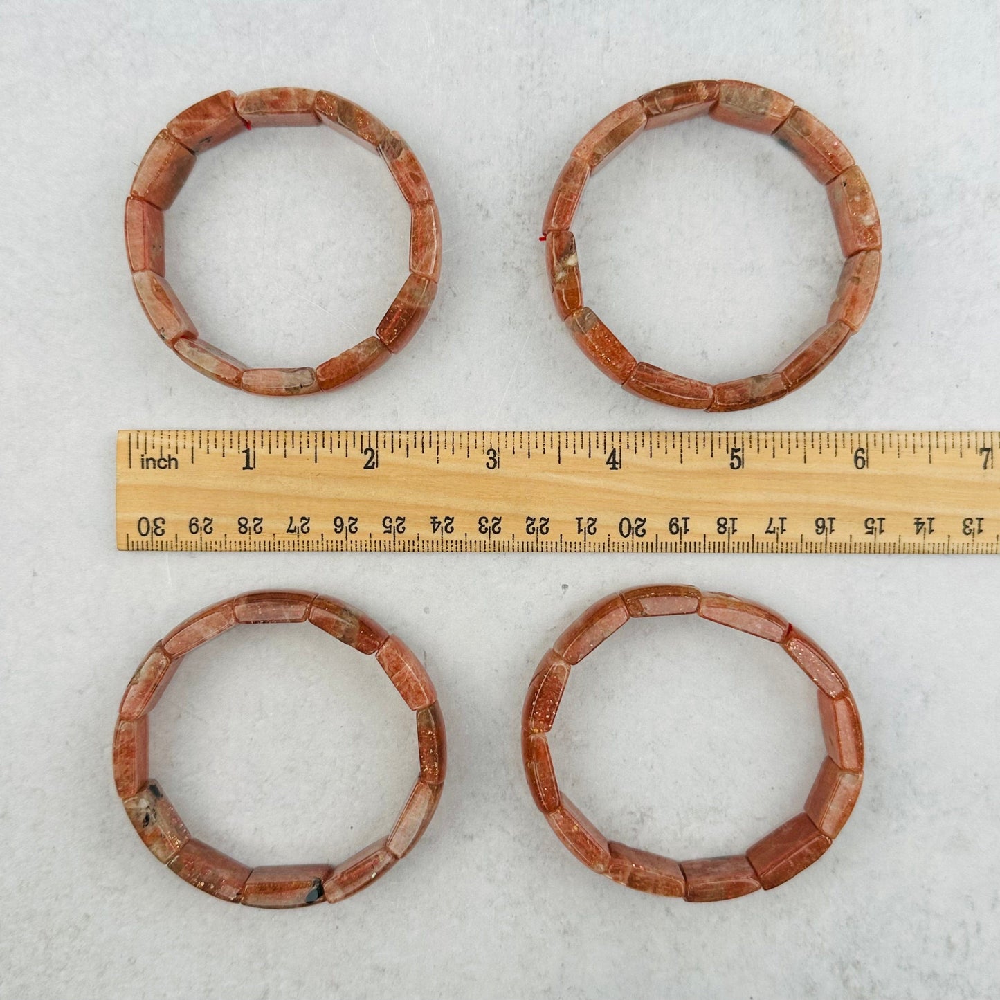 bracelets next to a ruler for size reference