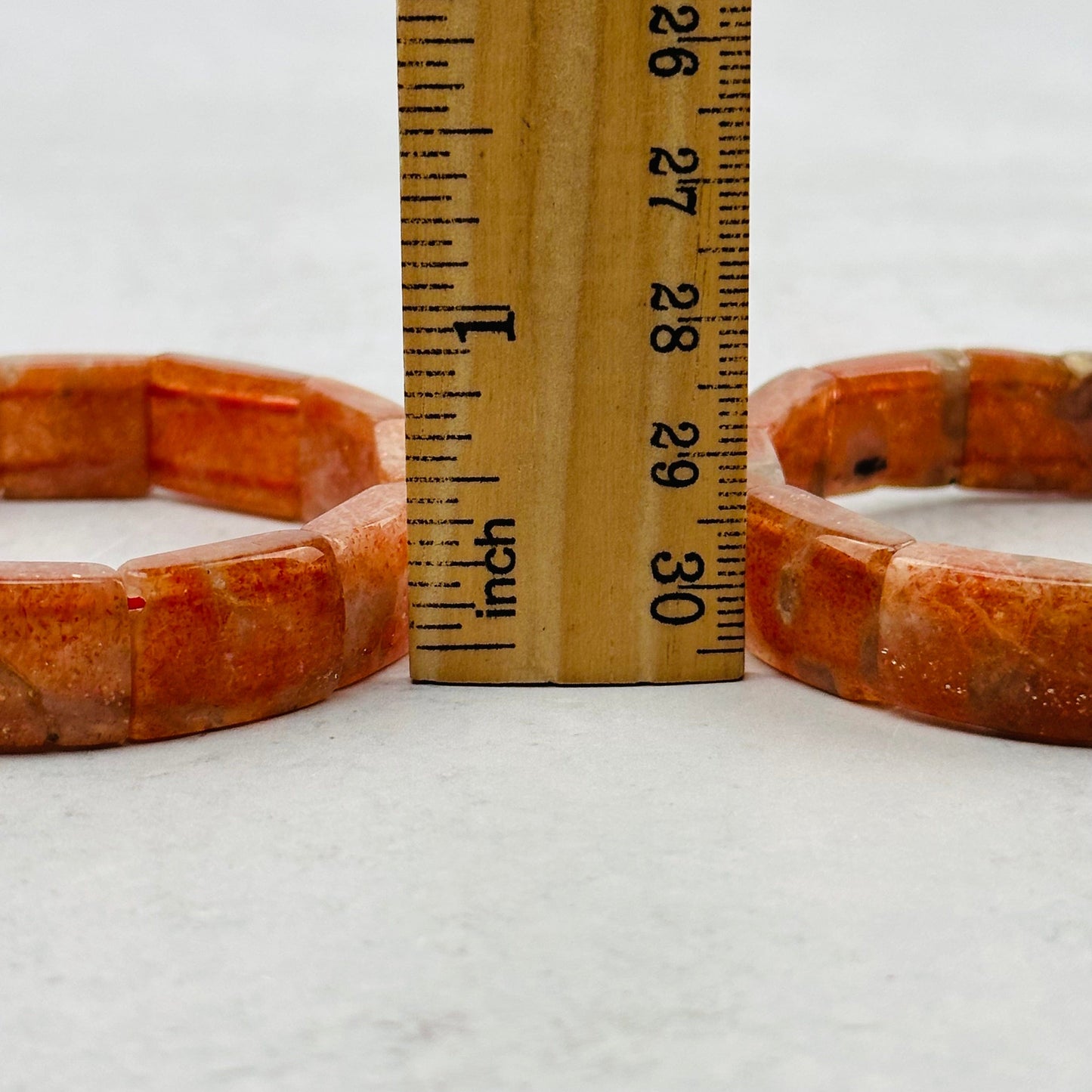 bracelets next to a ruler for size reference 