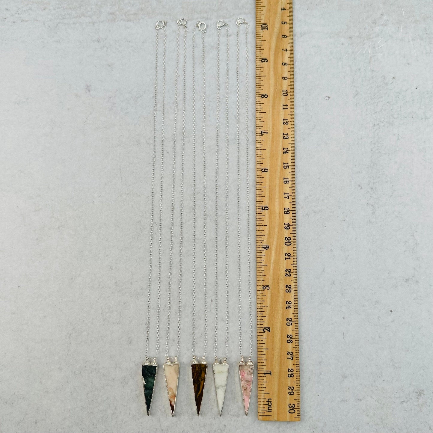 necklaces next to a ruler for size reference 