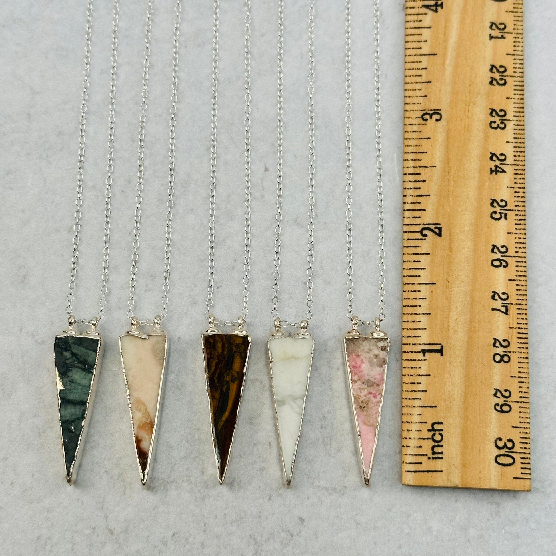pendants next to a ruler for size reference 