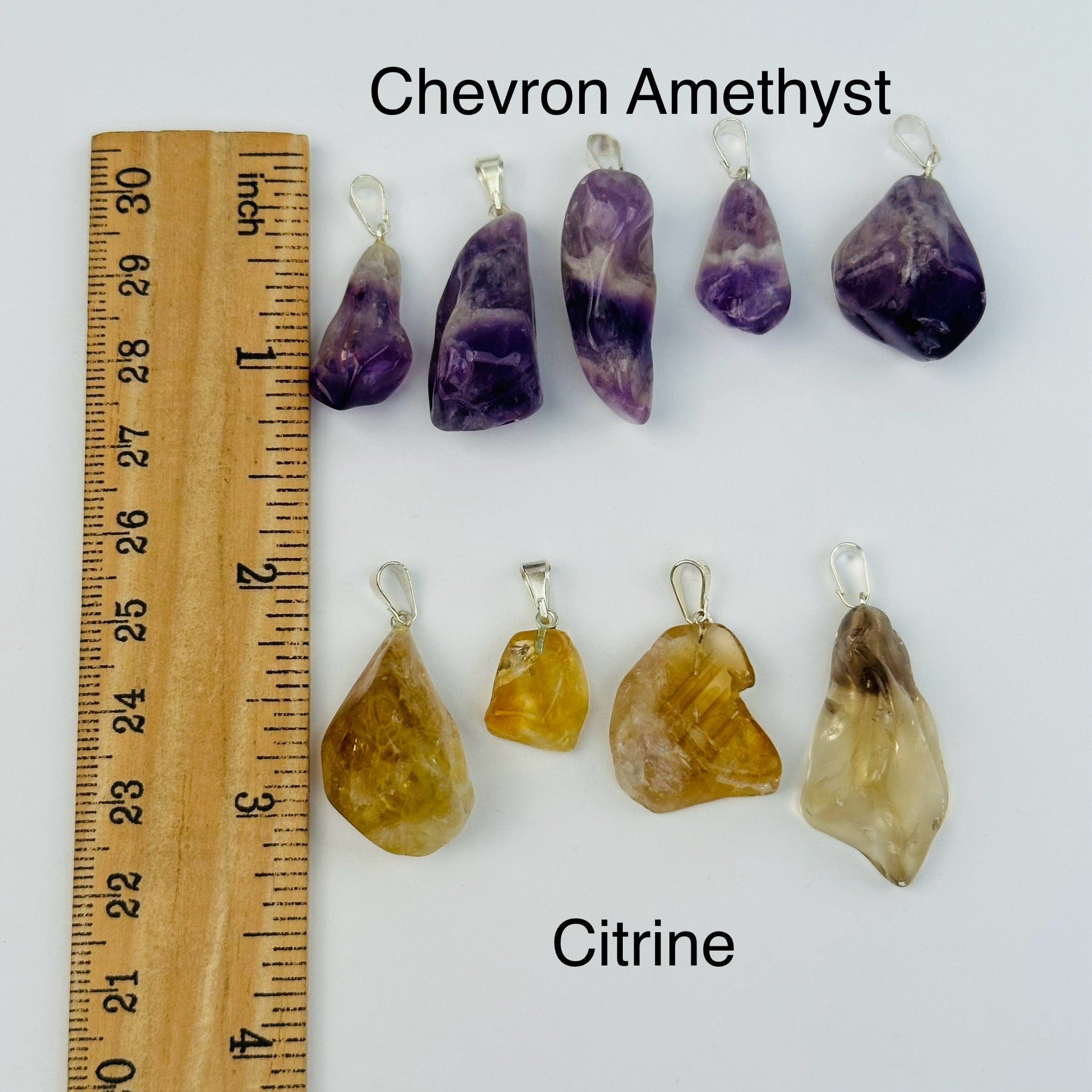 pendants next to a ruler for size reference 