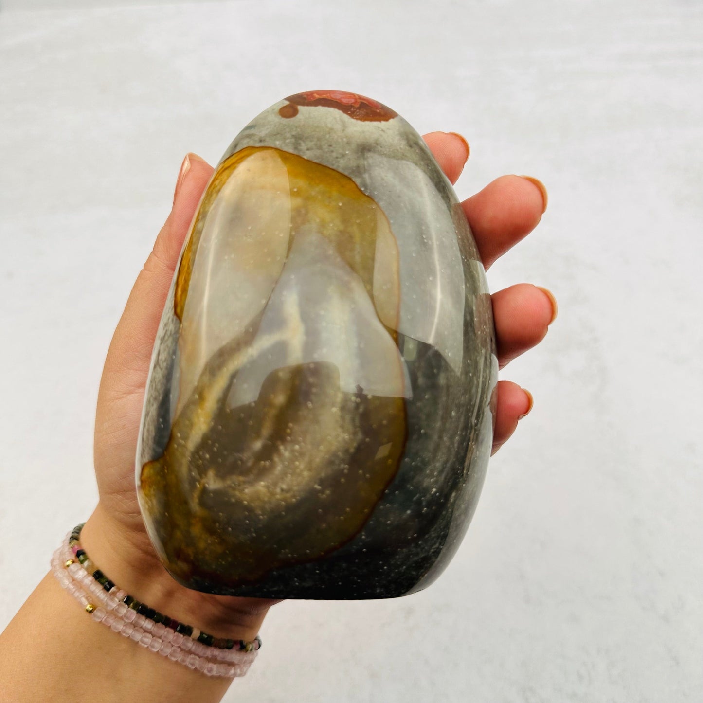 Polychrome Jasper Cut Base in hand for size reference 