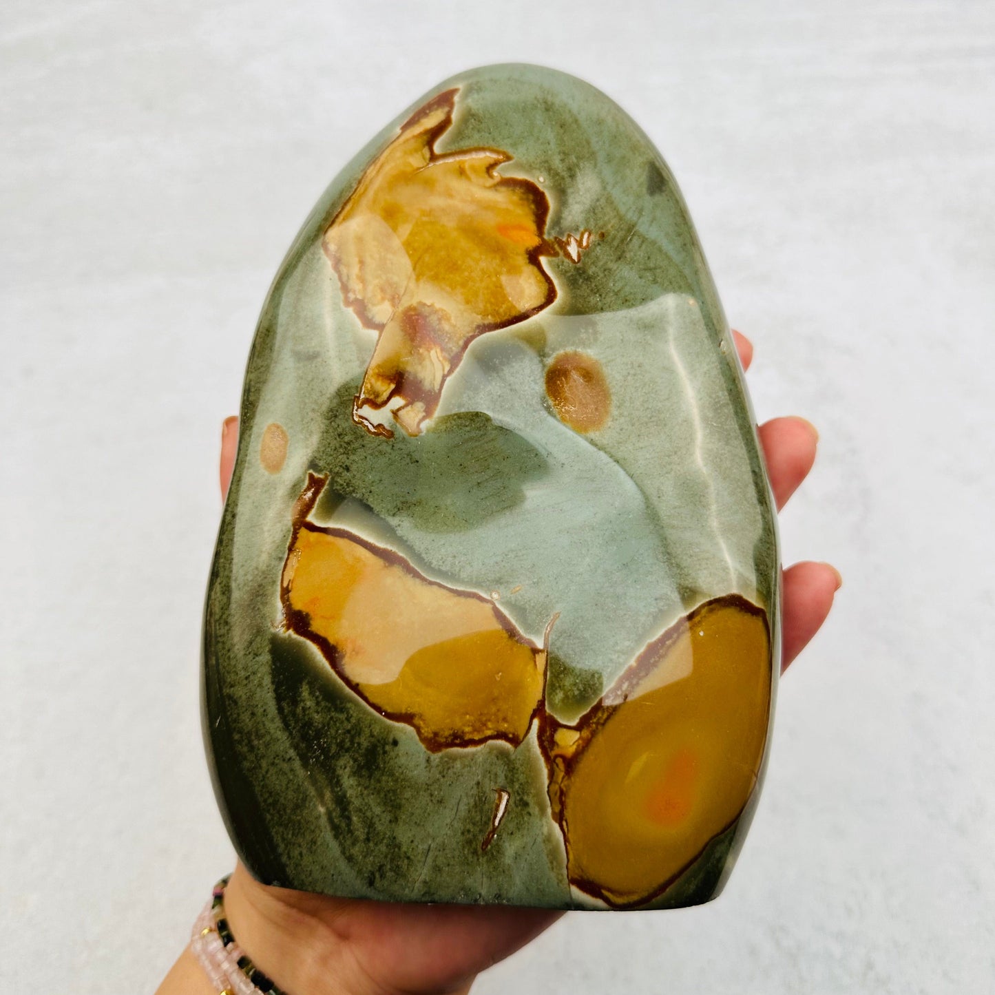 Polychrome Jasper Cut Base in hand for size reference 
