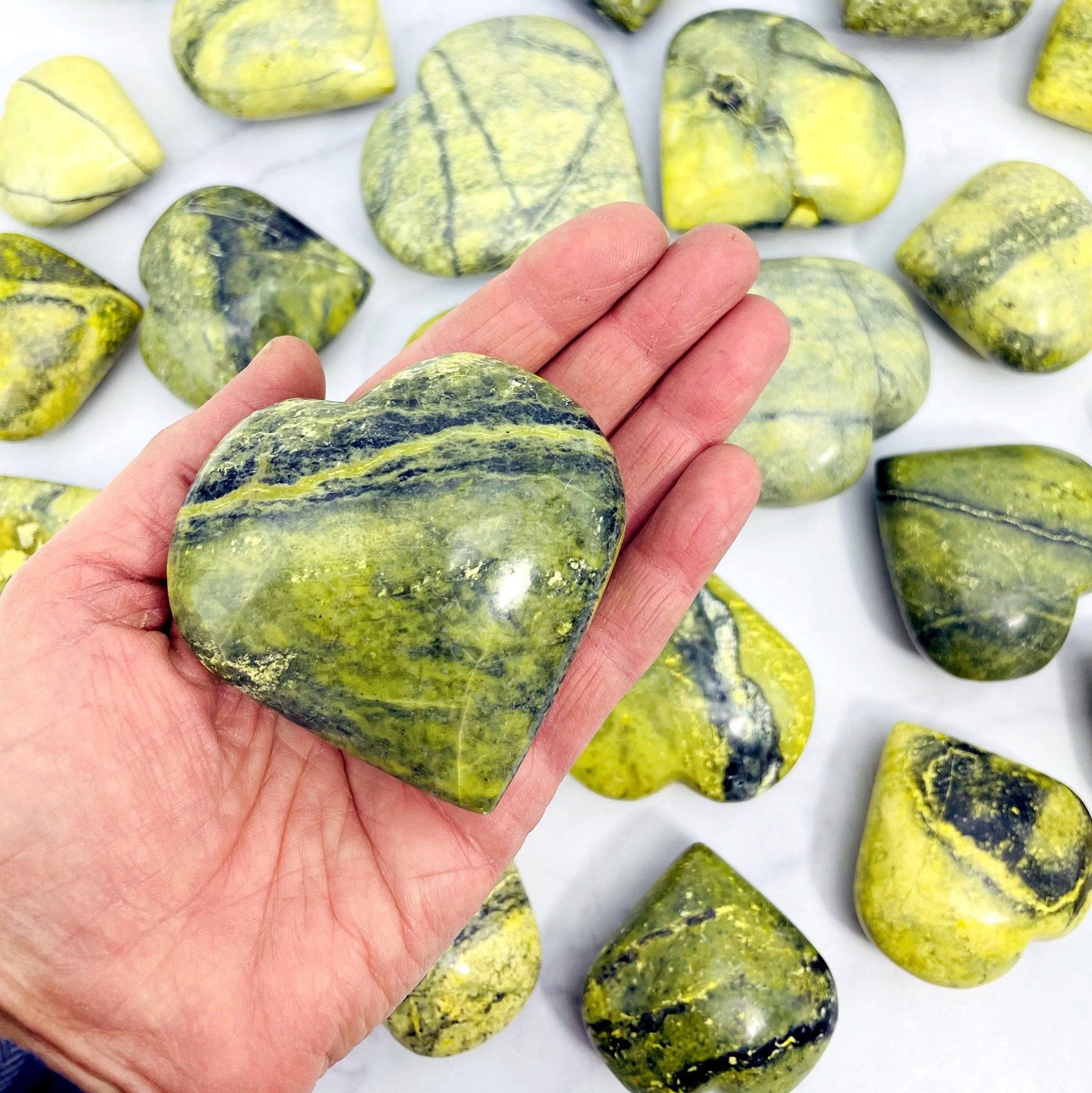 one 200g-300g  serpentine polished heart in hand for size reference with others in background