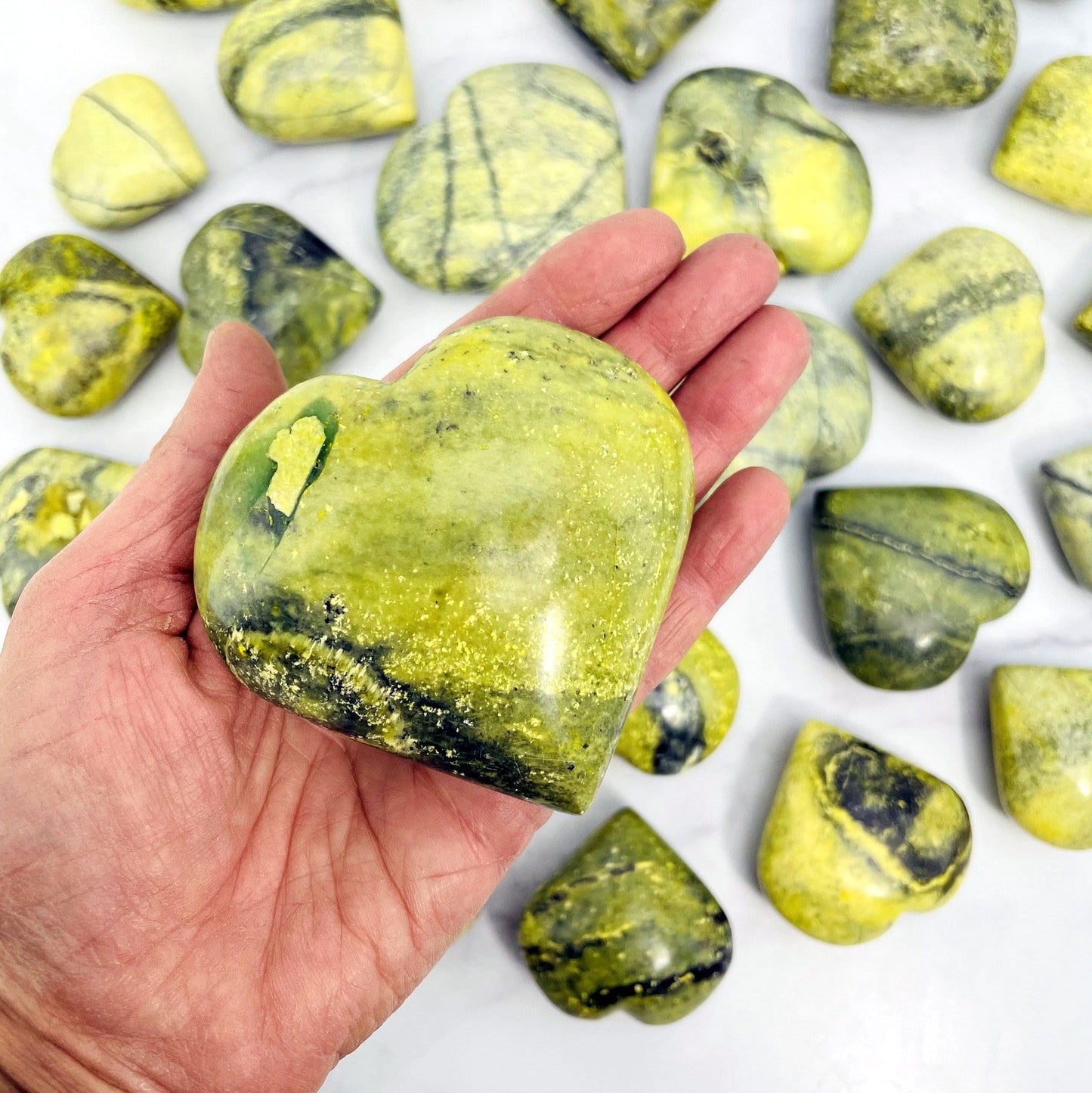 one 300g-400g  serpentine polished heart in hand for size reference with others in background