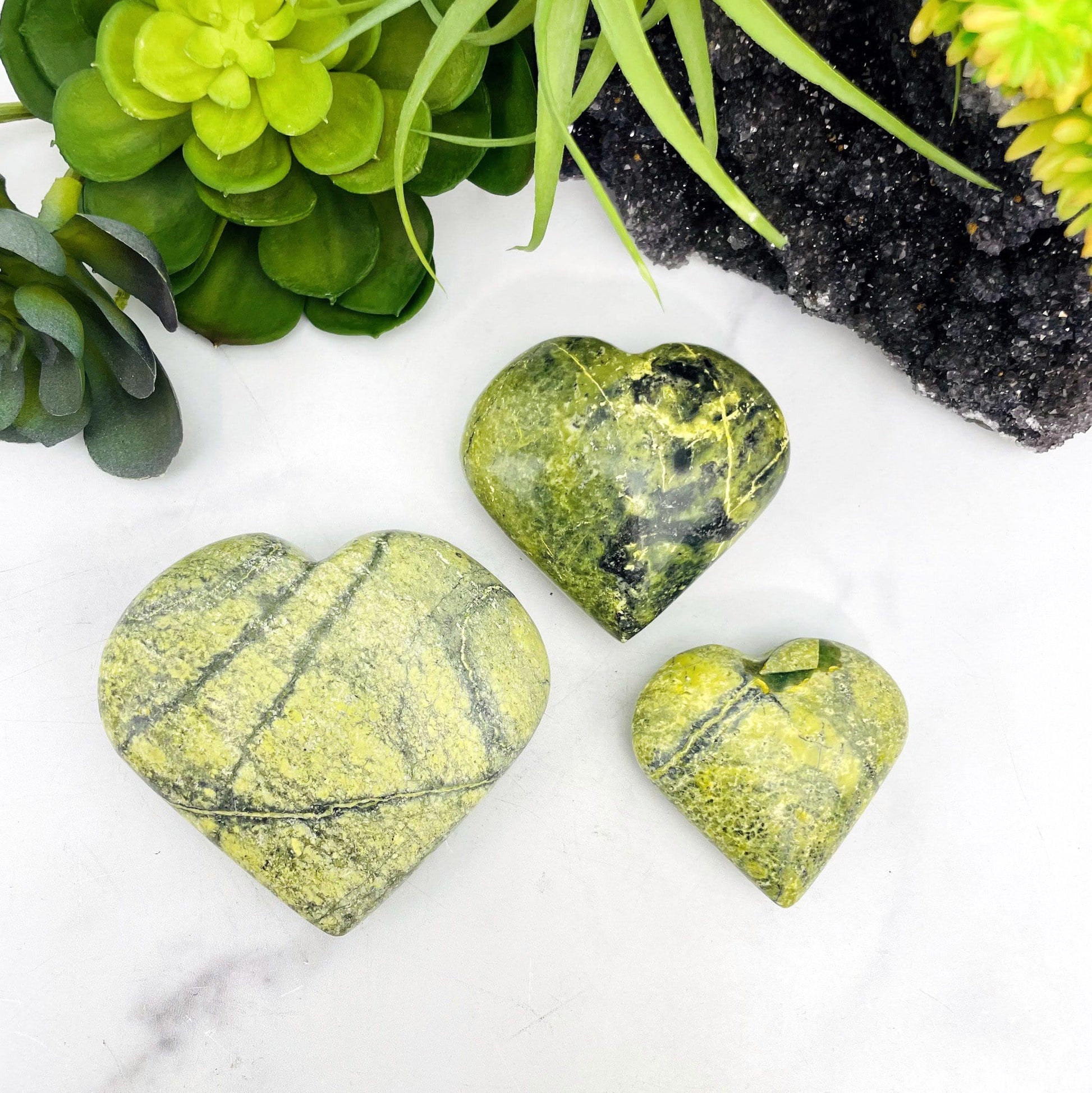 overhead view of all three serpentine polished heart weight options on display for size comparison