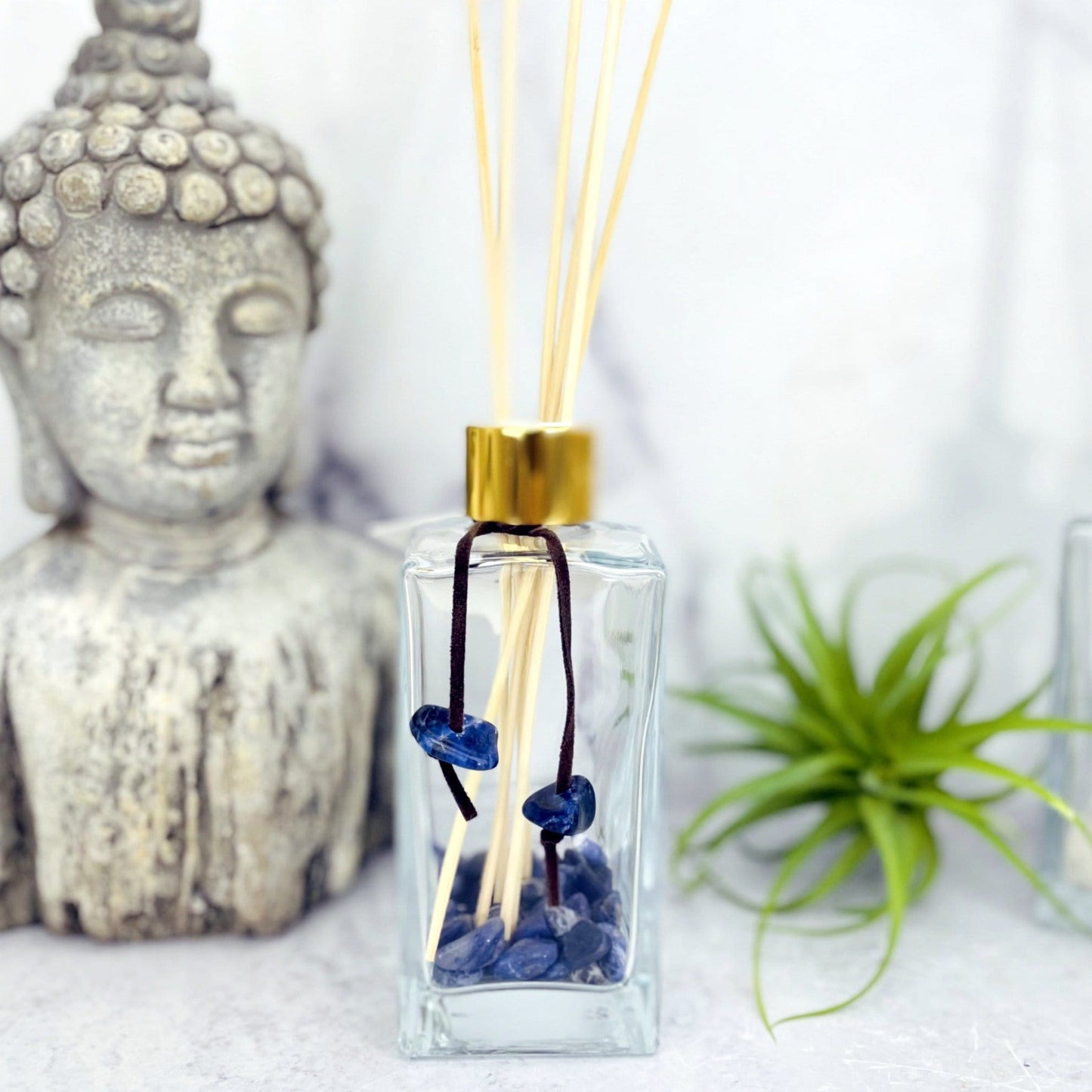 Tumbled Stone Diffuser Bottle--front shot view of glass bottle with stones on string.