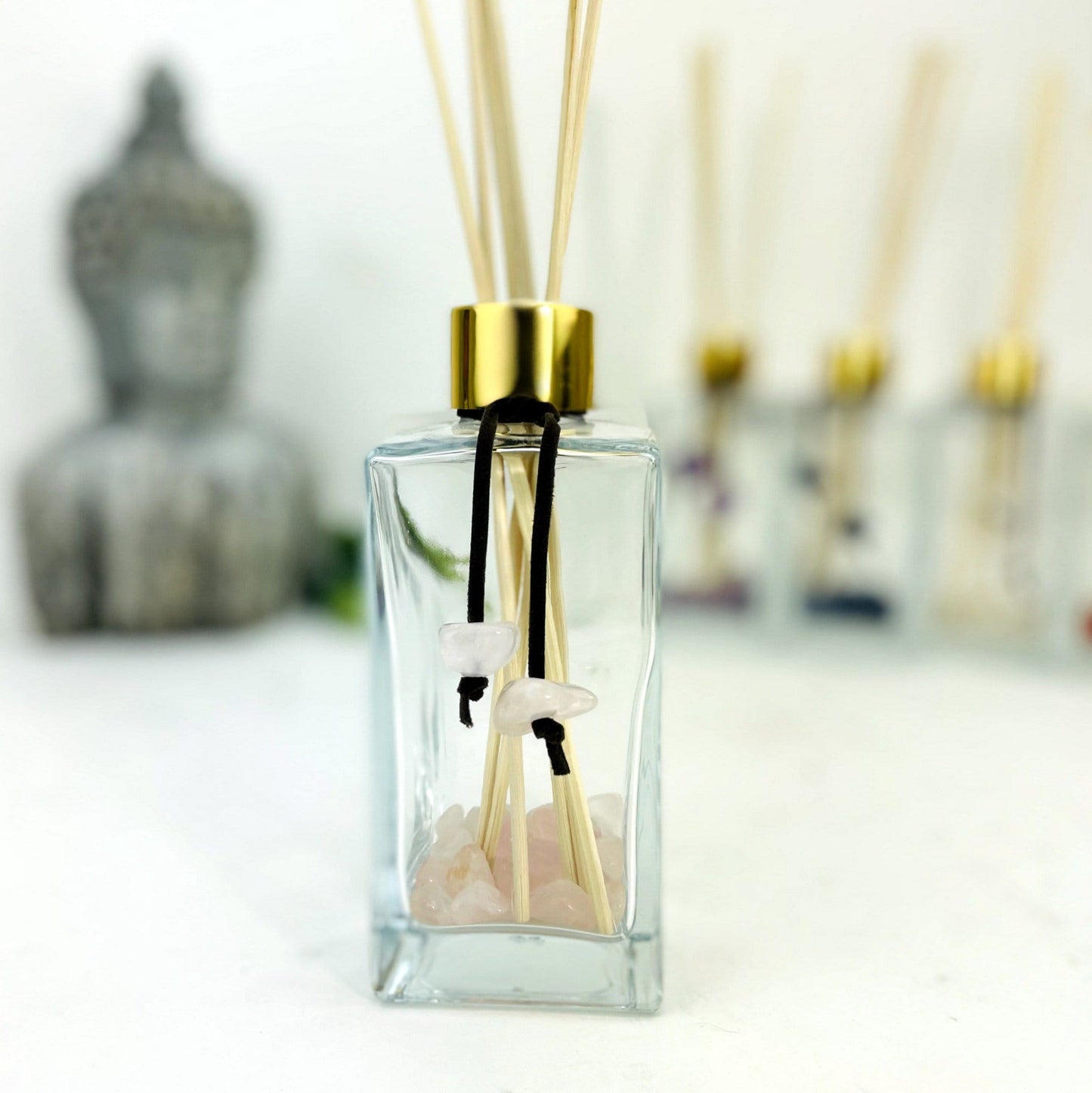 Tumbled Stone Diffuser Bottle--front view shot of glass bottle with rose quartz stone on string.