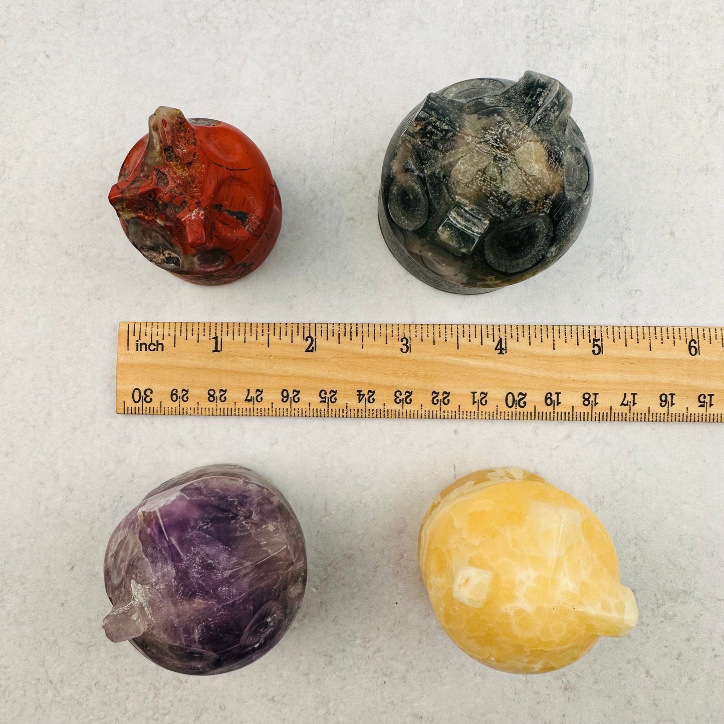 carved gemstone houses next to a ruler for size reference 