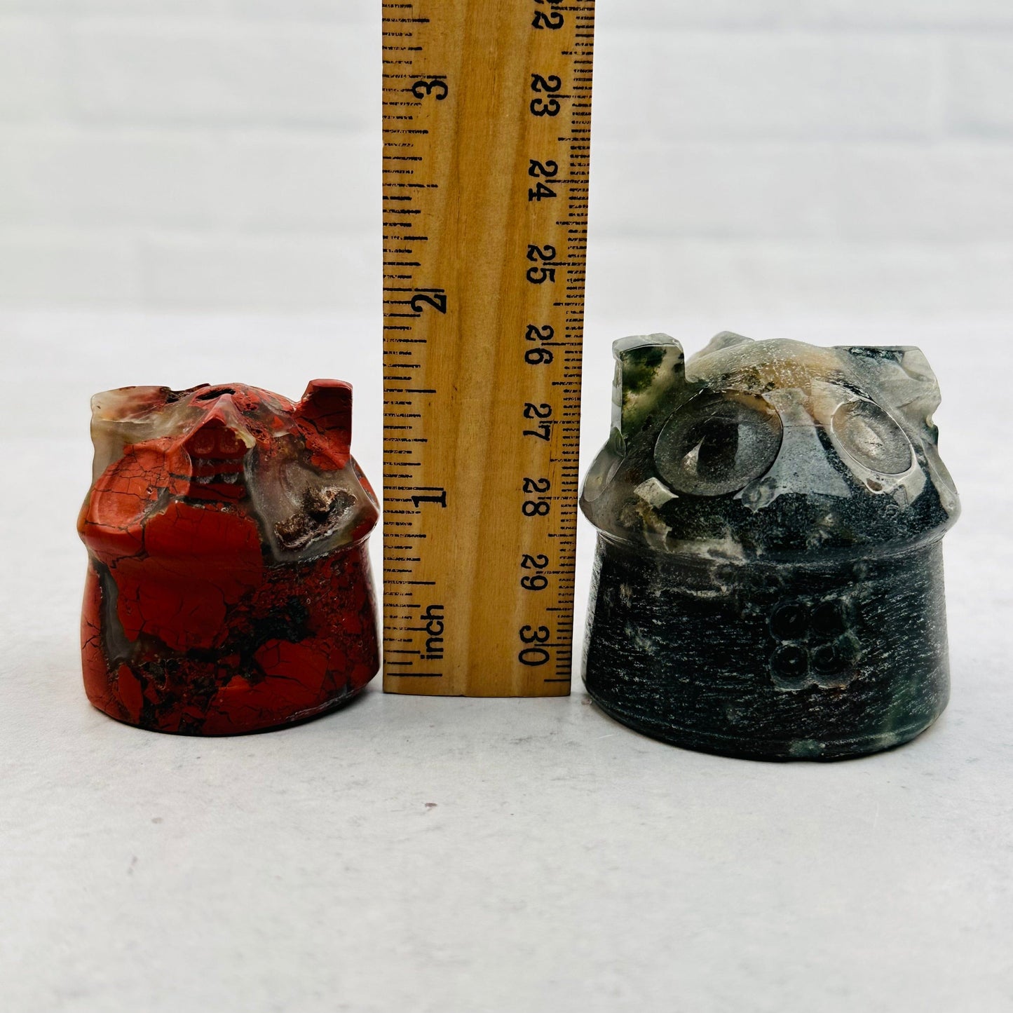 carved gemstone house next to a ruler for size reference 