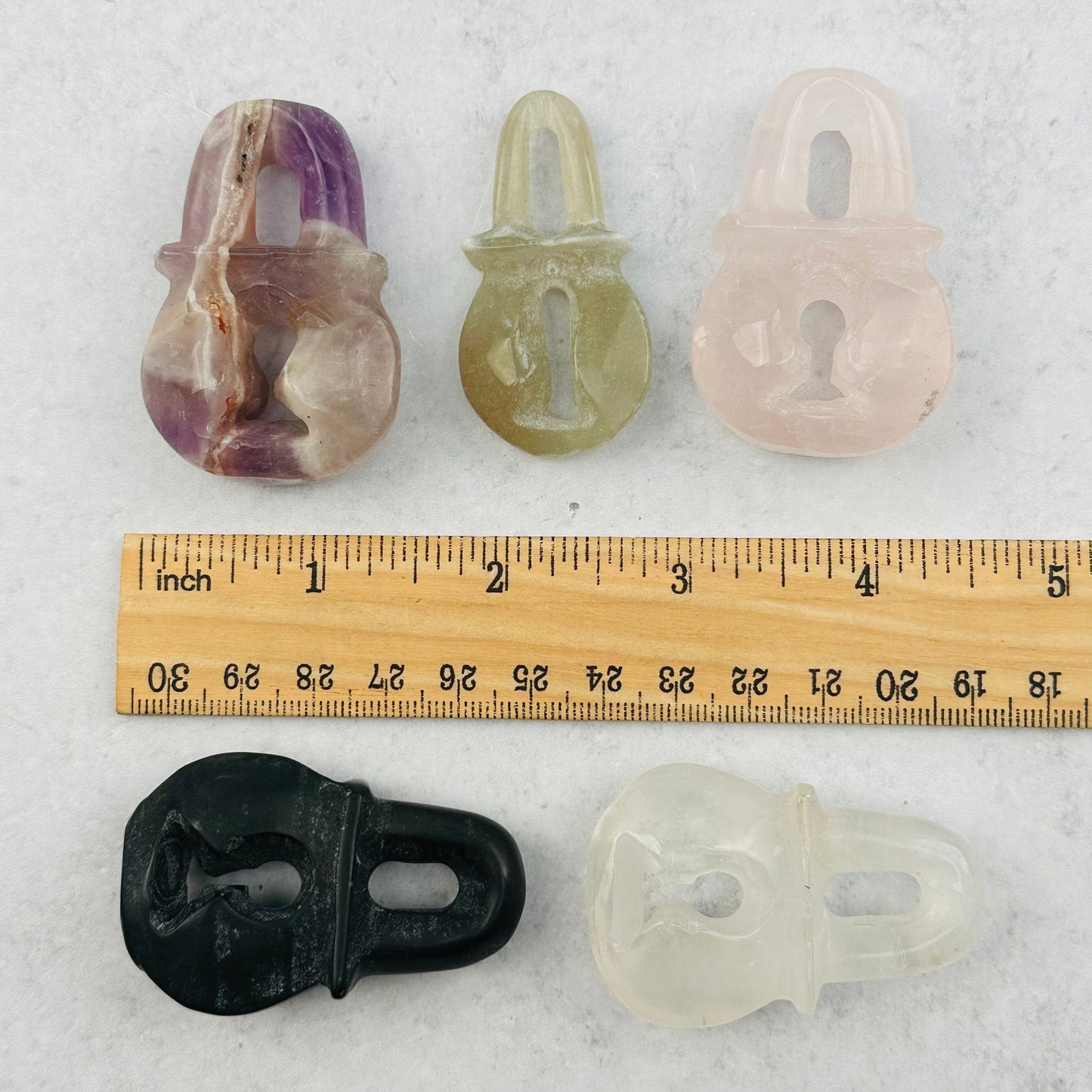 gemstone lock next to a ruler for size reference 