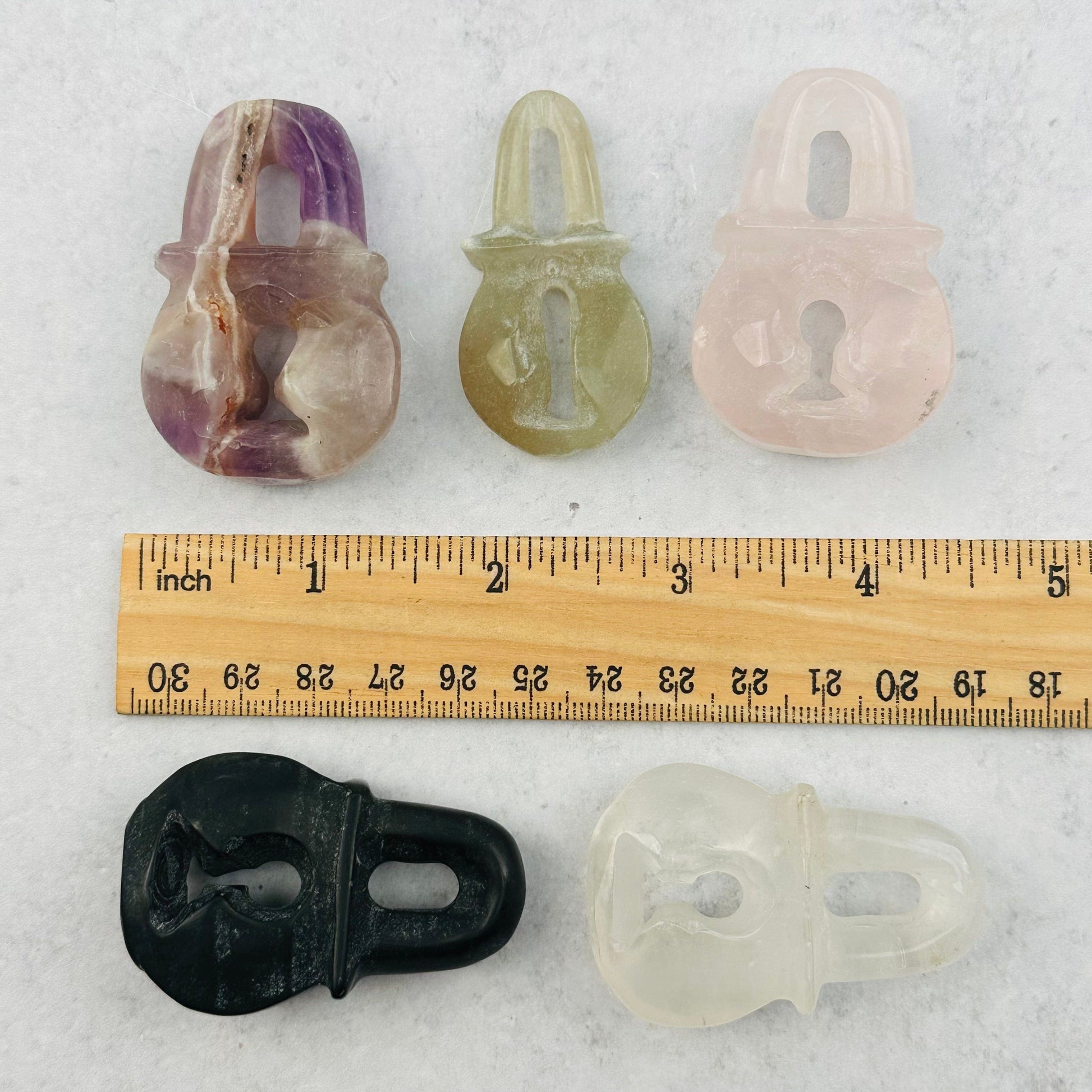 gemstone lock next to a ruler for size reference 