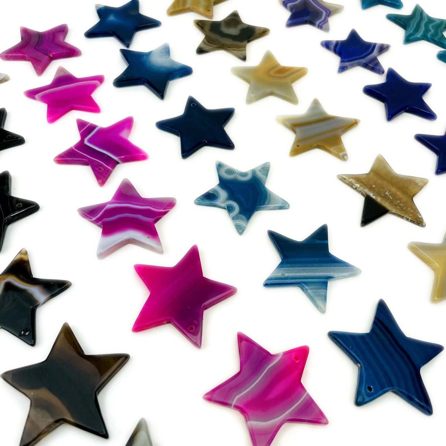 Close Up of Assorted Drilled Agate Stars Different Color on White Background.