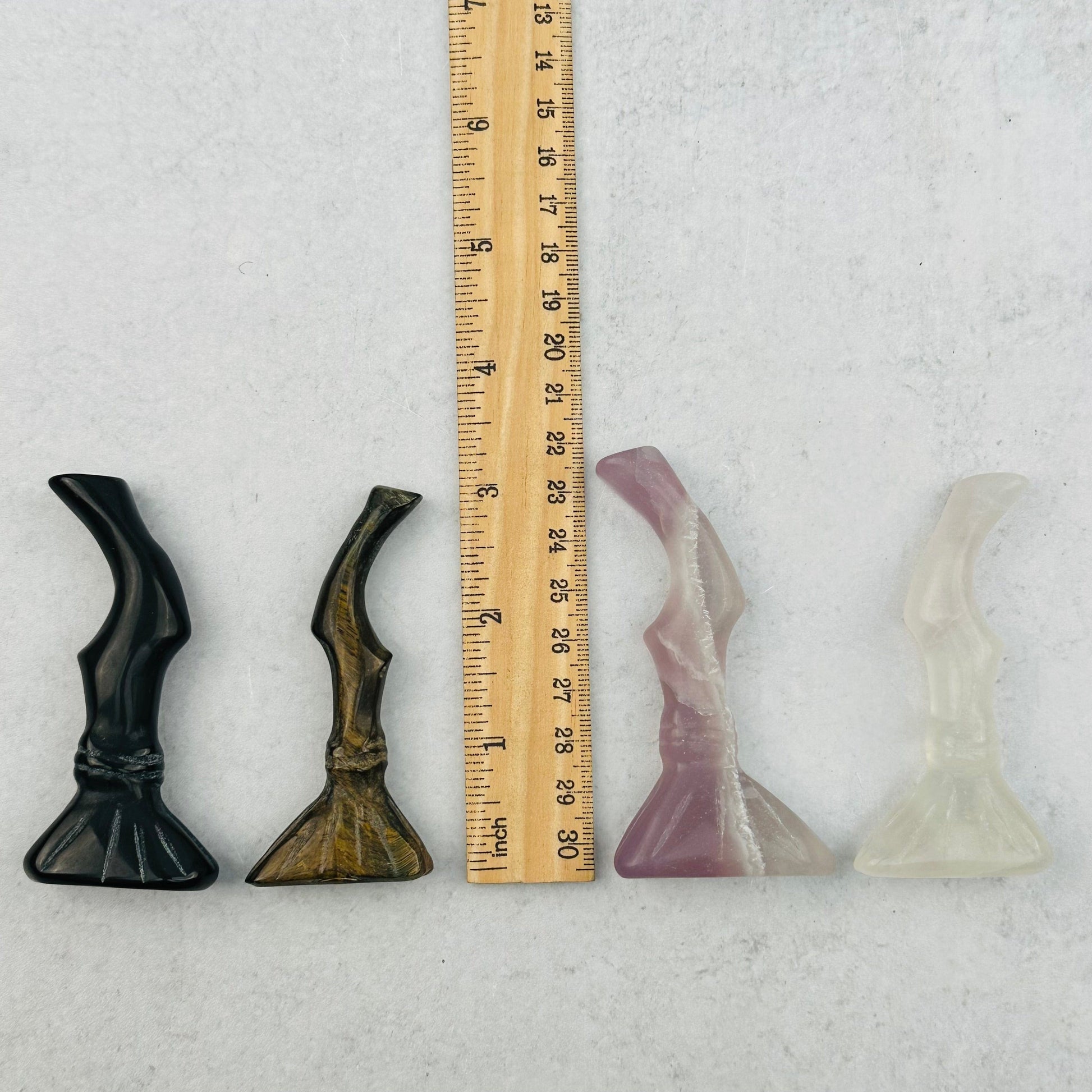 Carved Gemstone Brooms next to a ruler for size reference 