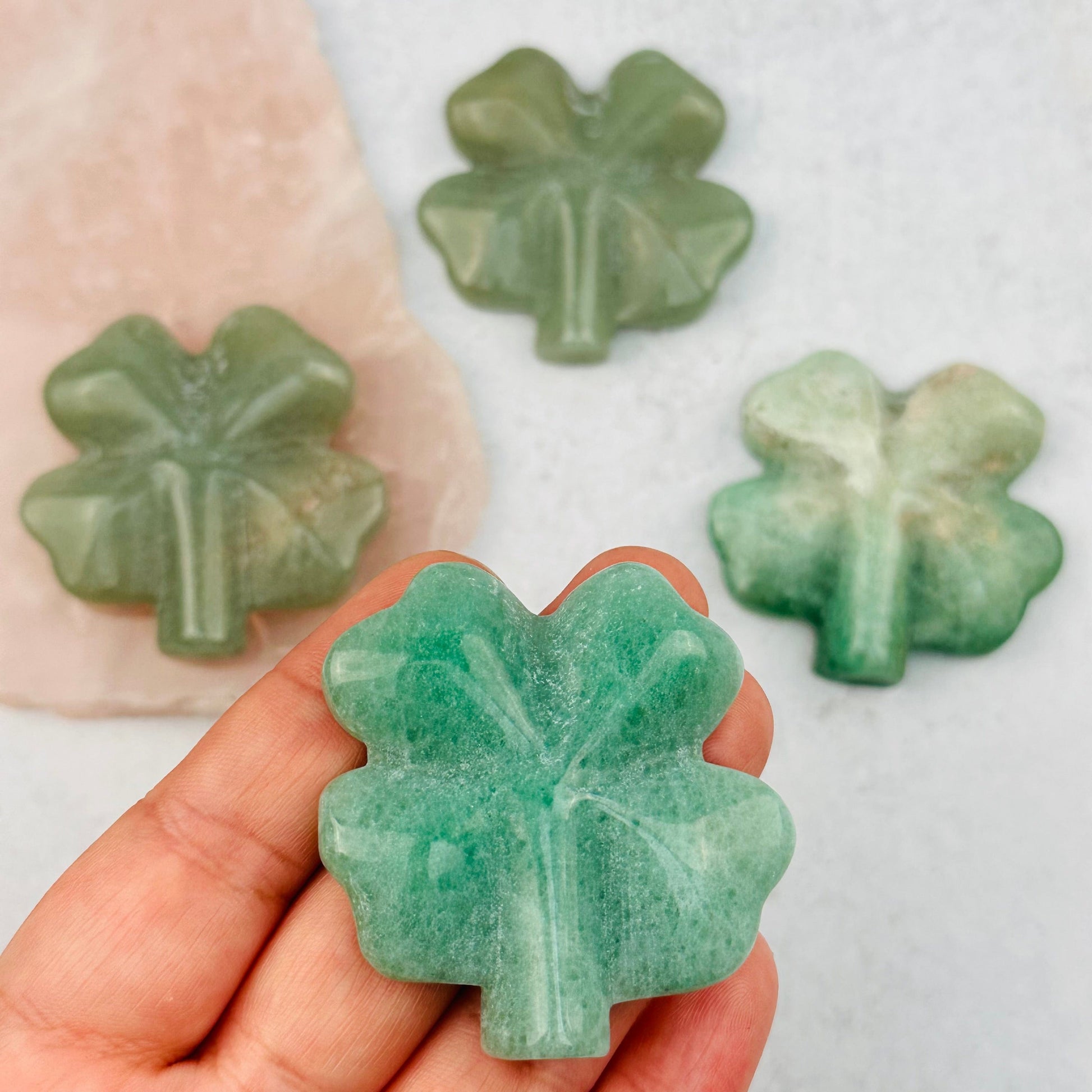 Green Aventurine Carved Gemstone Clover in hand for size reference 