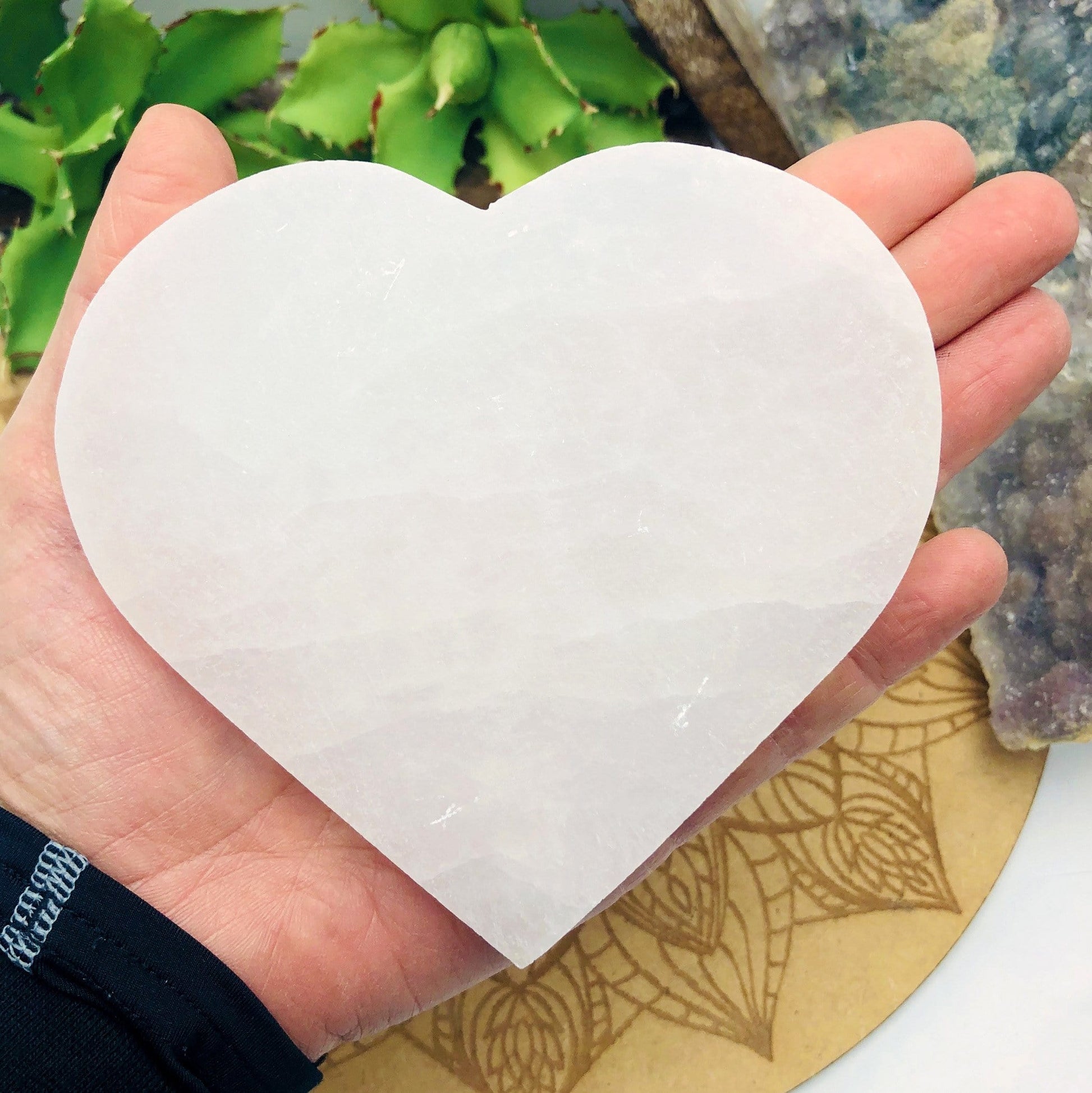 selenite flat heart in hand for size reference