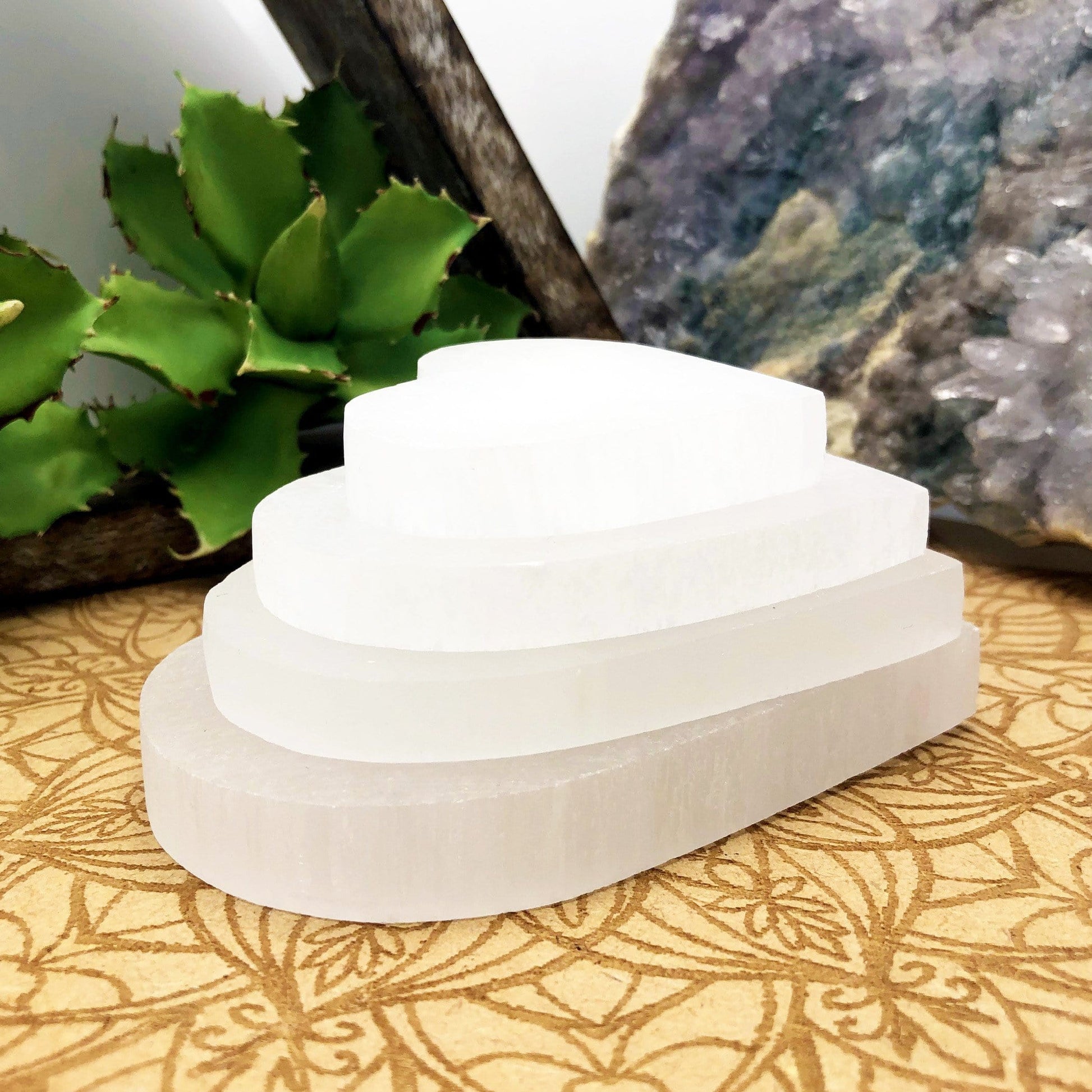 side view of selenite flat heart sizes stacked for thickness and size comparison 
