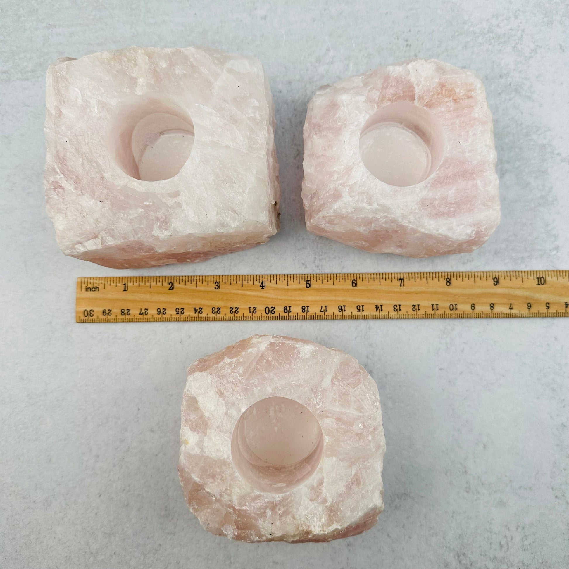 rose quartz candle holders displayed next to a ruler for size reference 