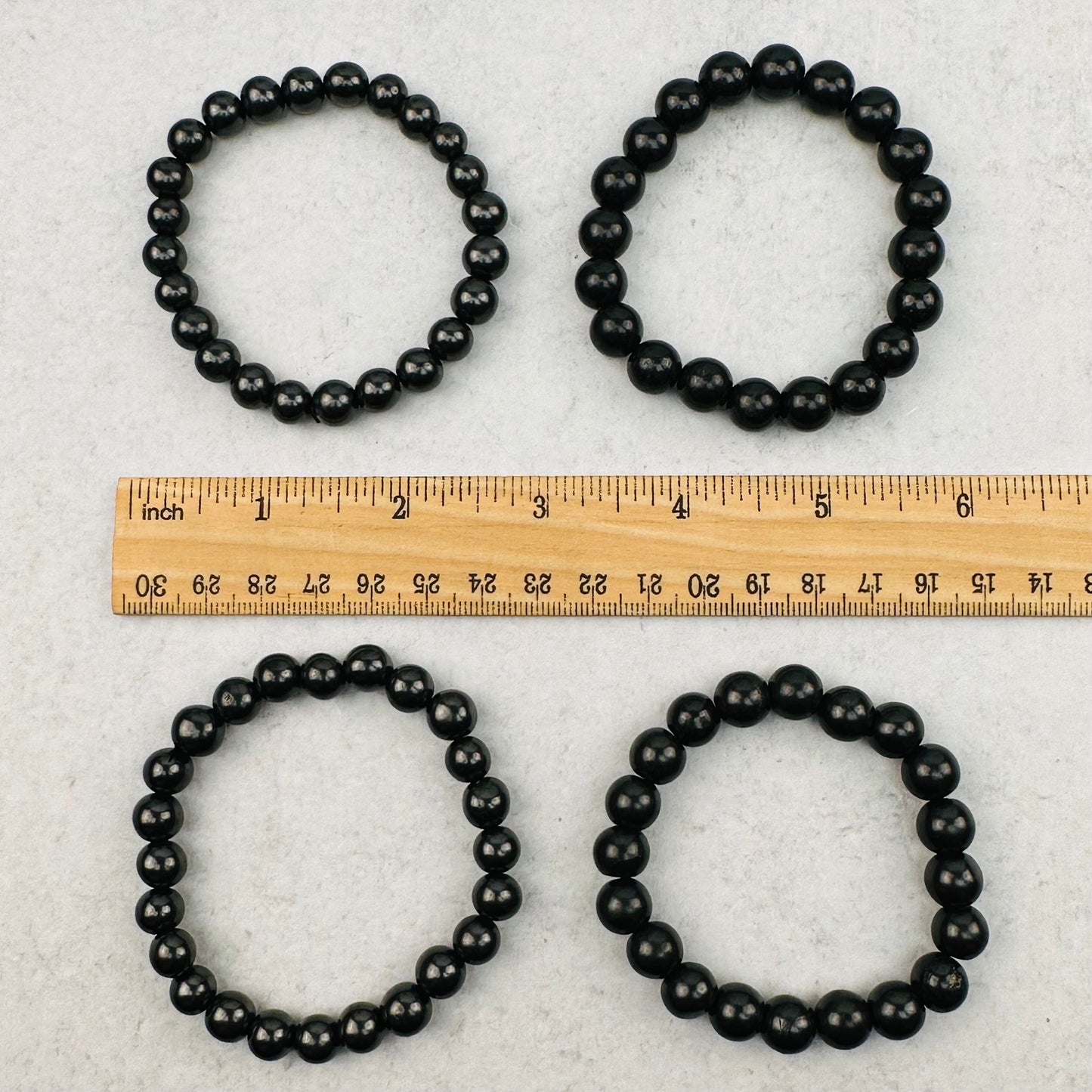 bracelets next to a ruler for size reference 