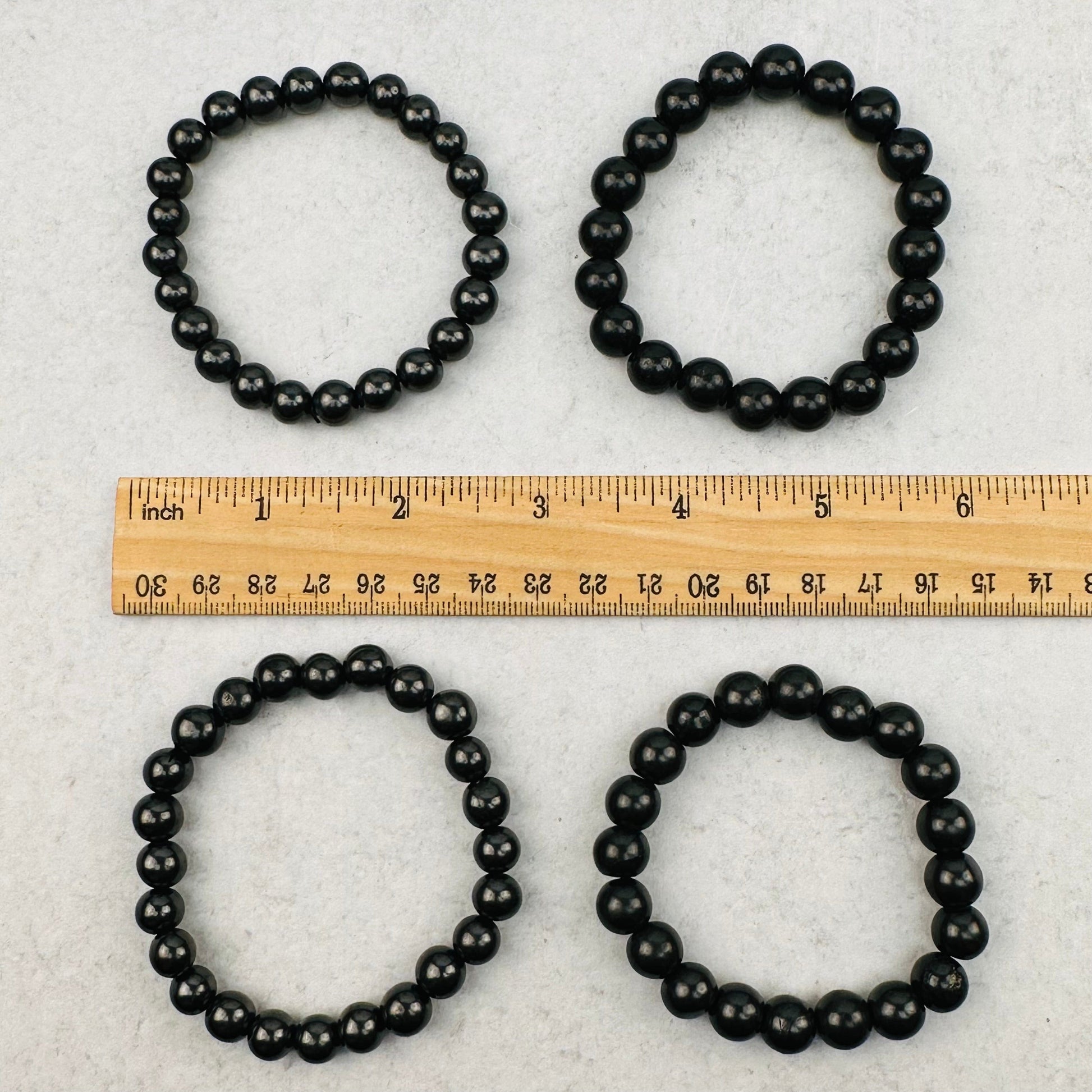 bracelets next to a ruler for size reference 