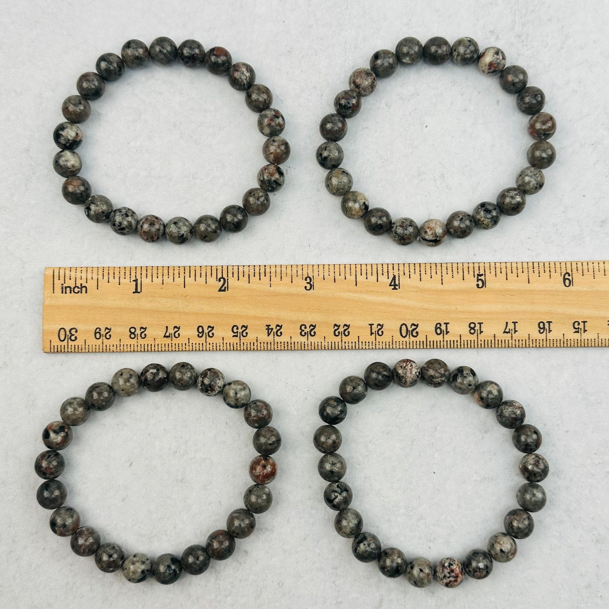 bracelets next to a ruler for size reference 