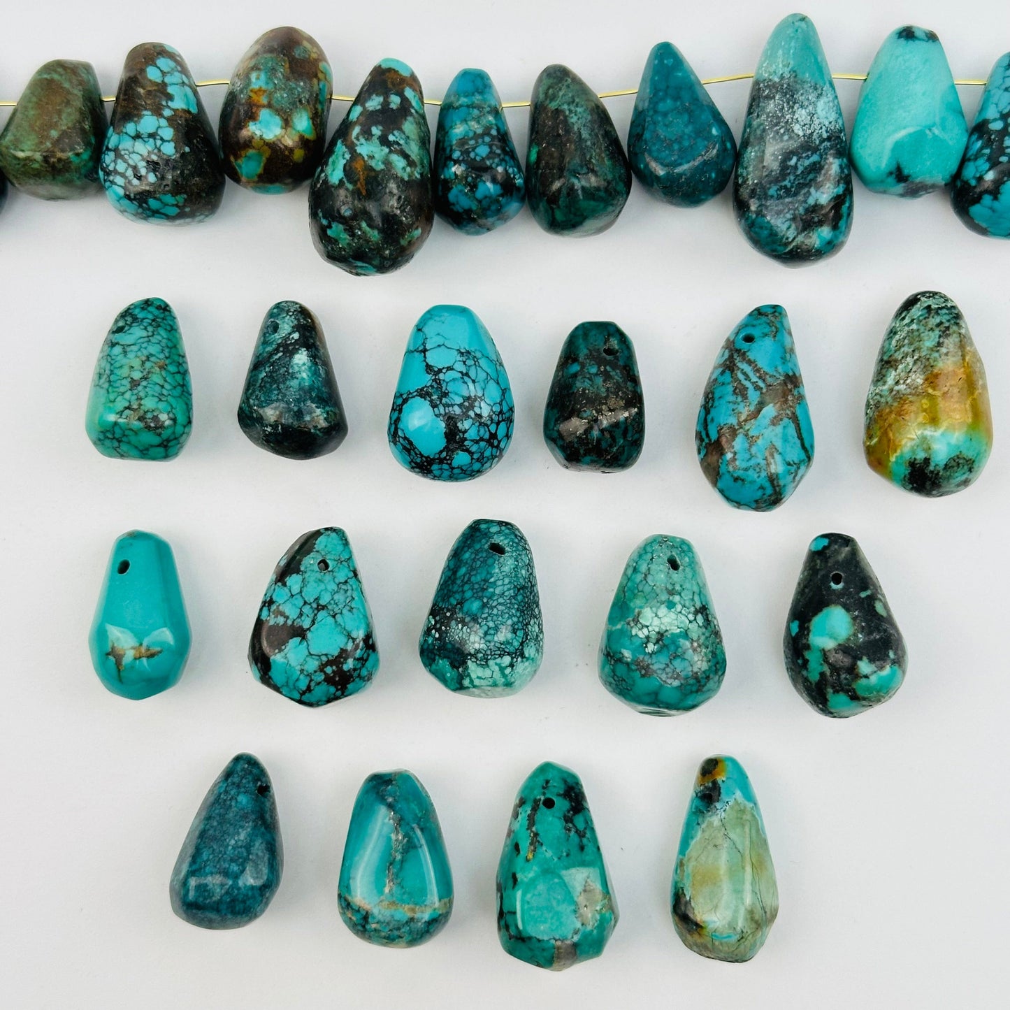 multiple turquoise beads displayed to show the differences in the sizes and color shades 