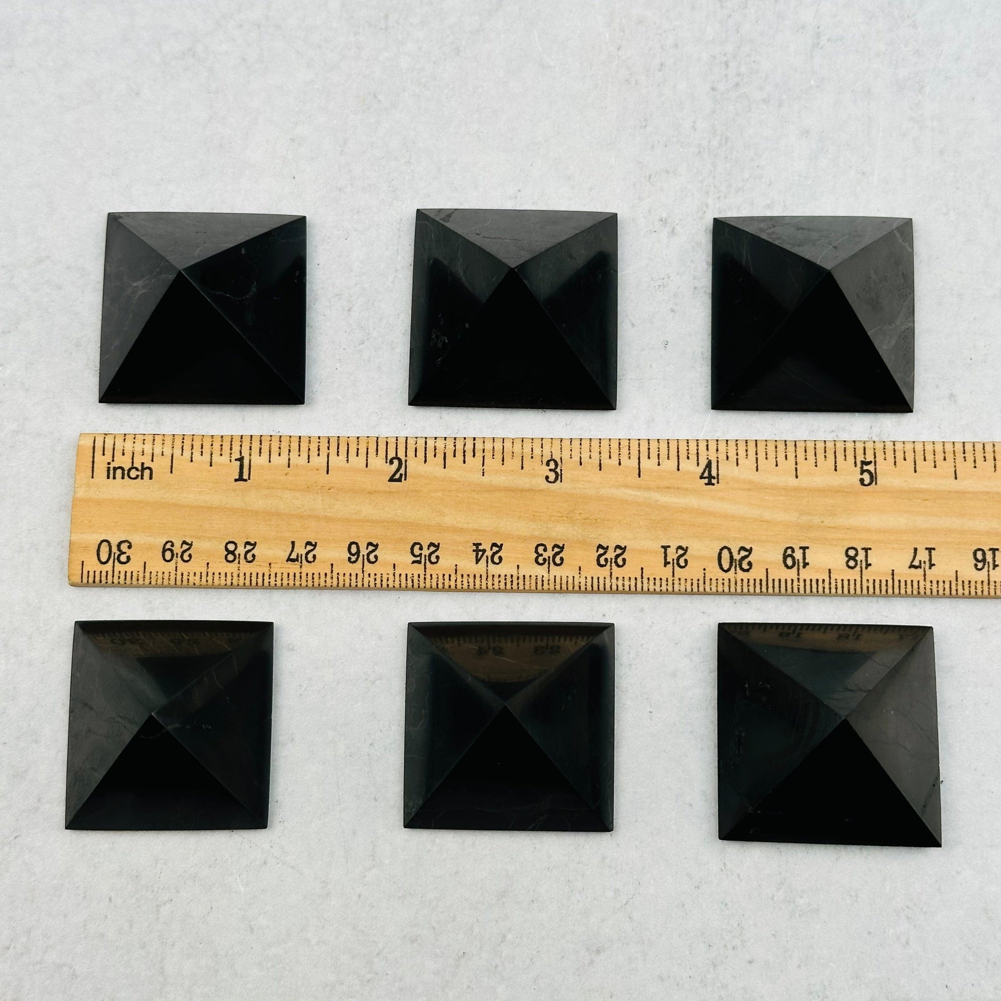 Shungite Pyramids next to a ruler for size reference 