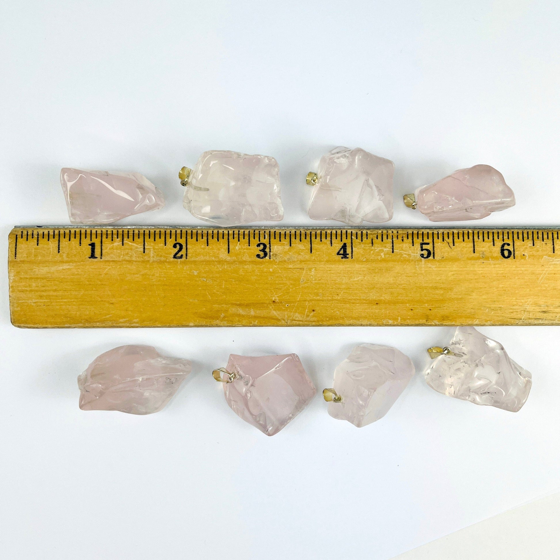 Crystal Rose Quartz Polished Free Form Pendants with Silver Bails, next to a ruler for sizing