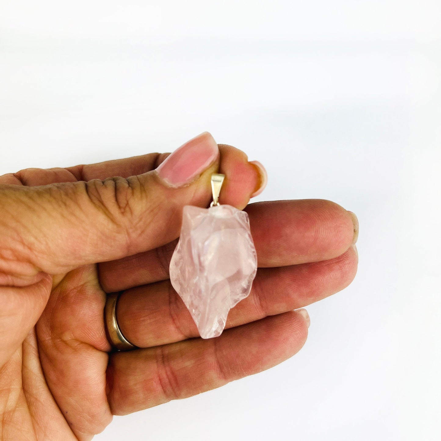 Crystal Rose Quartz Polished Free Form Pendant with Silver Bail in a hand for size reference