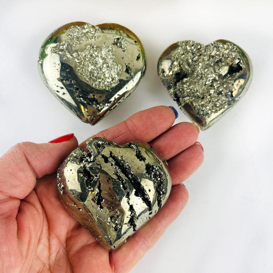 3 Pyrite Crystal Hearts with one in a hand for size reference