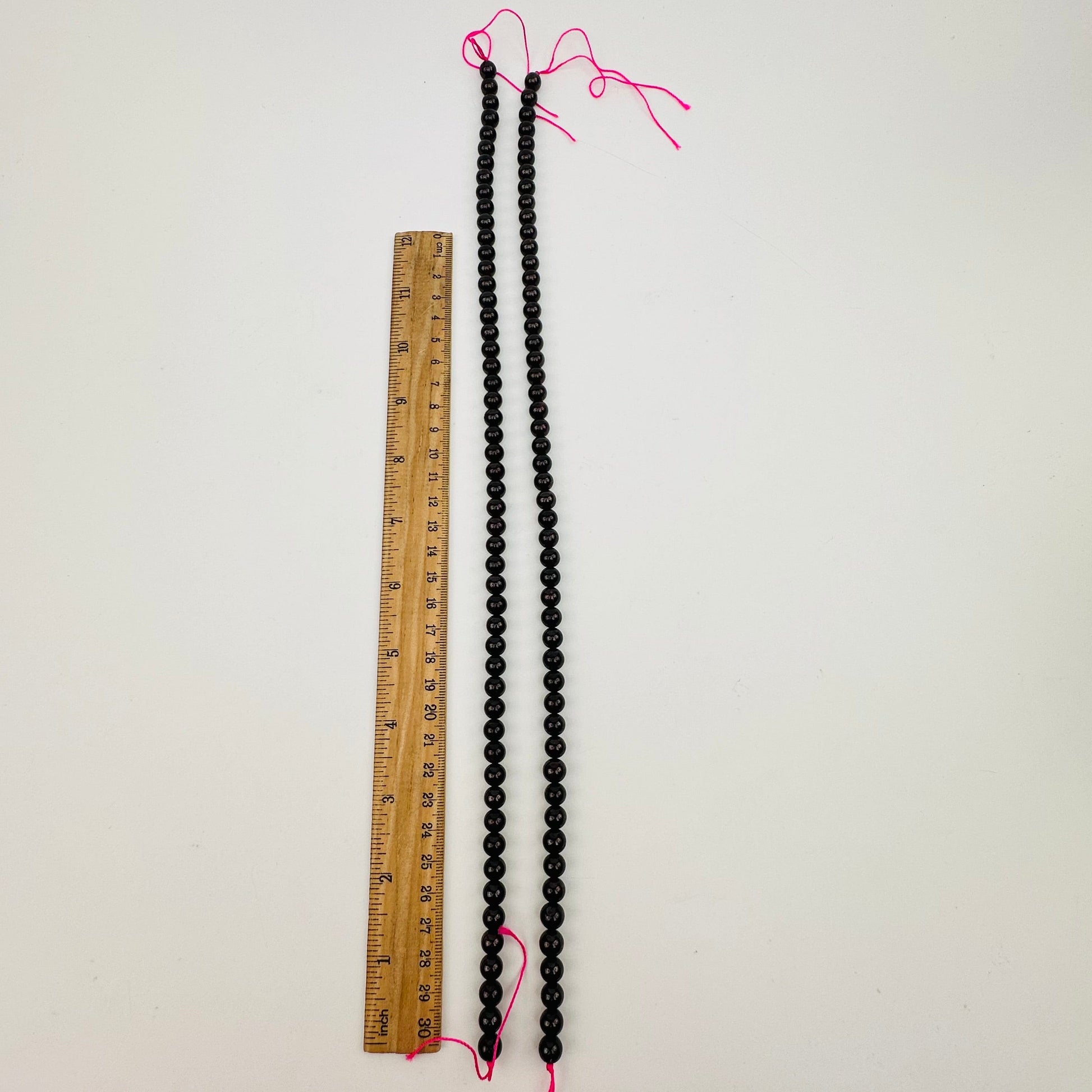 bead strands displayed next to a ruler for size reference 