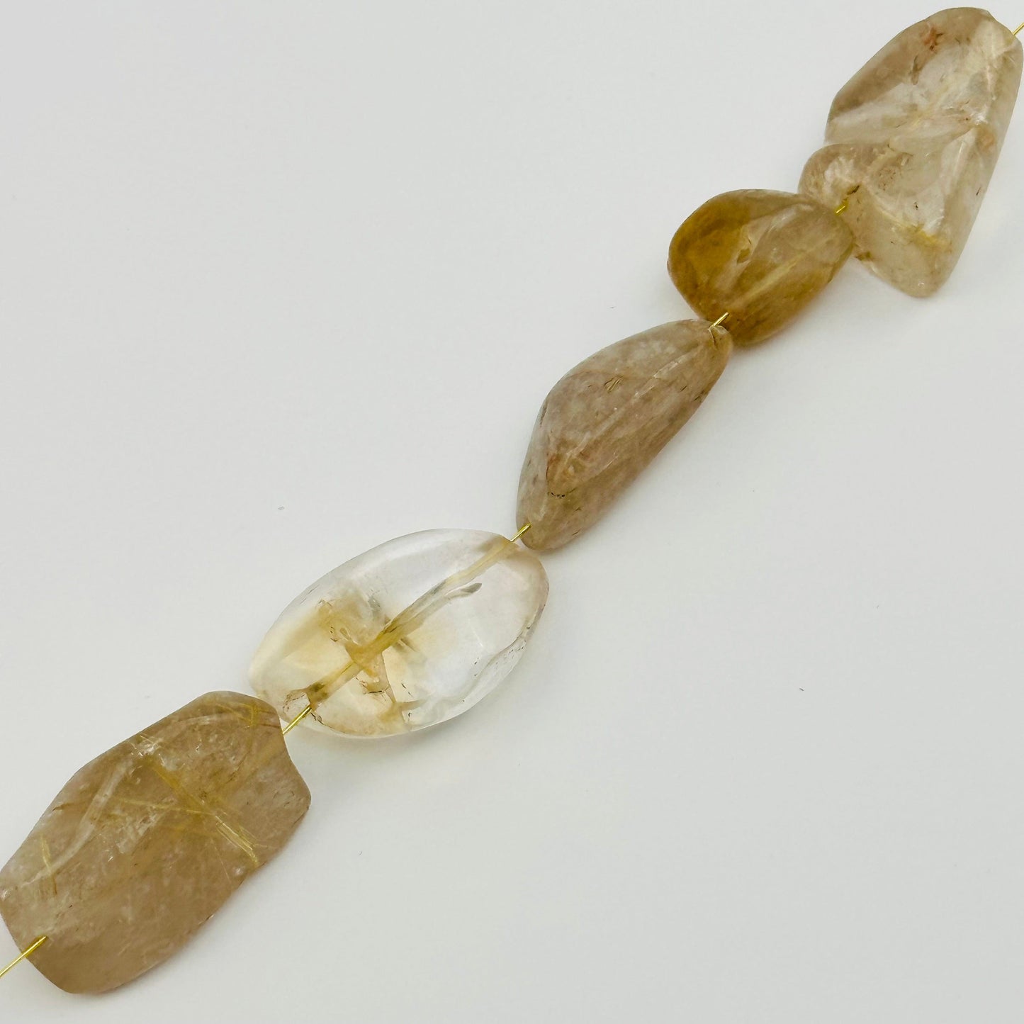 beads strung on string to show where it is drilled from 